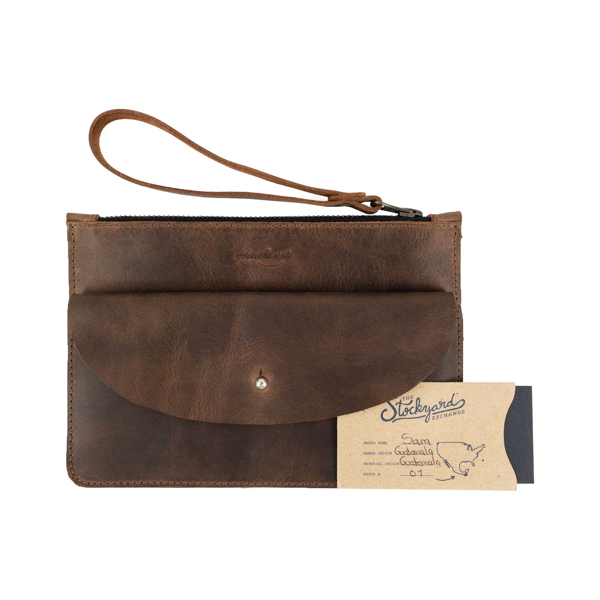 Heather's Clutch Bag with Extra Pouch alongside a quality tag. This artisan-made Full Grain Leather wrist wallet for cards shows the dedication to craftsmanship typical of handmade products from La Antigua Guatemala & Oaxaca Mexico.