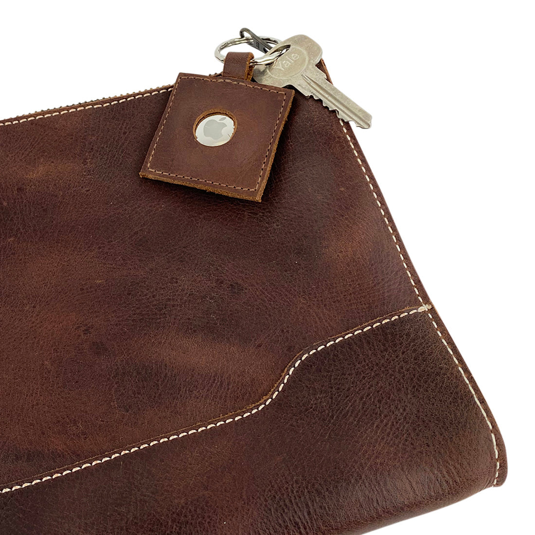 AirTag Squared Keychain by Hide & Drink attached to a bag, made of durable Full Grain Leather. This Squared AirTag Keychain combines technology with artisan craftsmanship for effortless tracking of personal items.