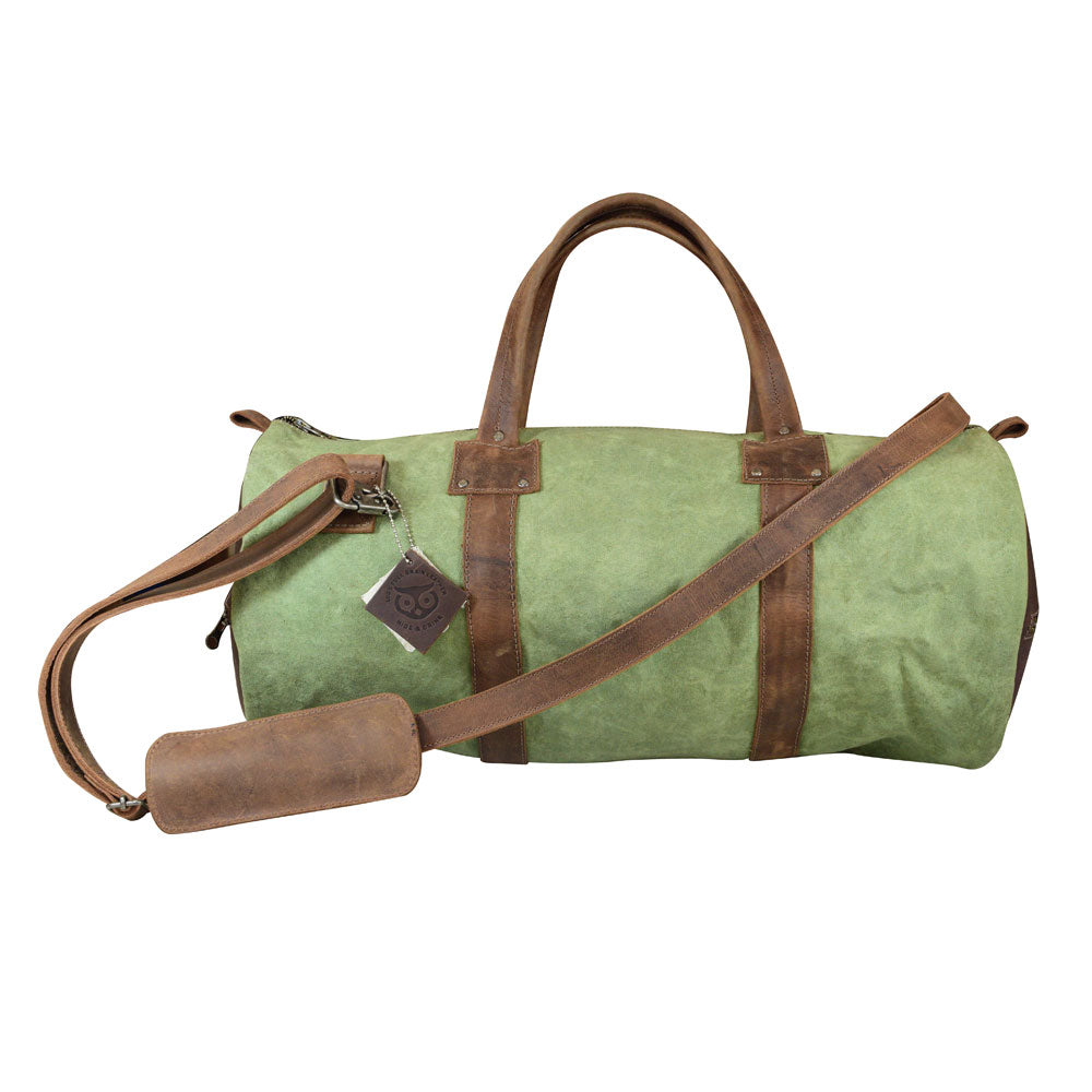 Classic Duffle Bag by Hide & Drink in green fabric, featuring a Full Grain Leather bottom, adjustable strap, and zipper closure. A perfect Messenger Bag for travel needs, this stylish crossbody bag is crafted by artisans in La Antigua Guatemala & Oaxaca Mexico.