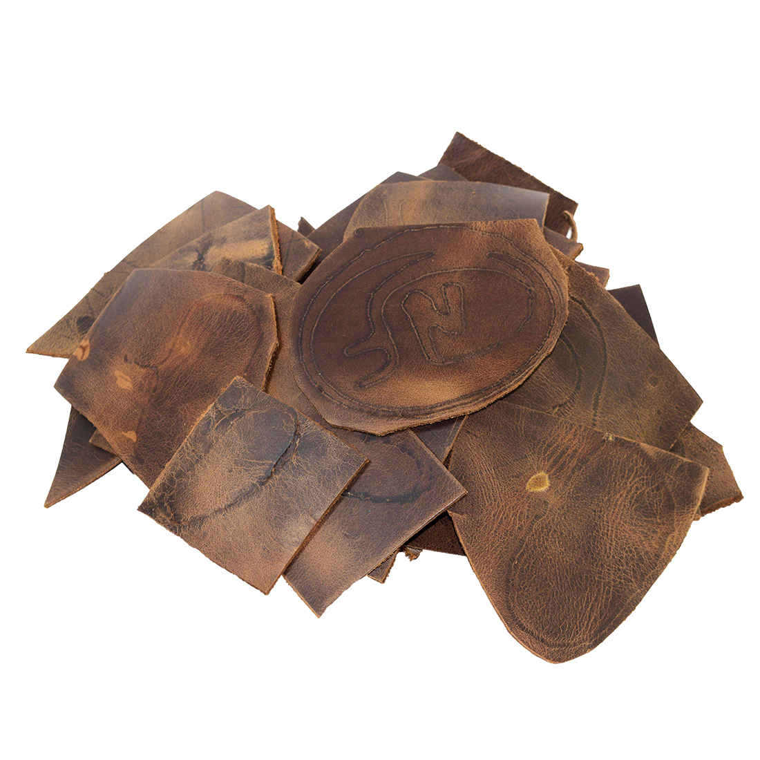 Hide & Drink Leather Scraps With Scars (12 oz pack) showcasing a pile of handcrafted full grain leather scraps, perfect for arts & crafts. These leather scraps are hand cut and feature scars that highlight their unique character. Ideal for various crafting projects, this selection includes different widths measuring 8 inches and longer, ensuring versatility. Artisan-made in La Antigua Guatemala, these scraps are small batch produced and fire branded for authenticity.