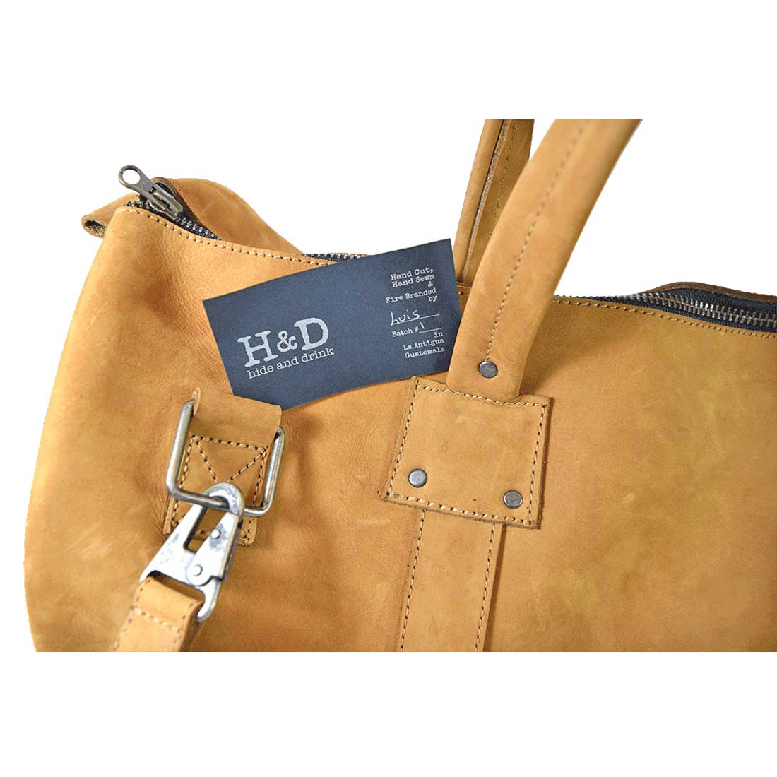 Detail view of the Classic Duffle Bag by Hide & Drink in orange suede, highlighting craftsmanship and quality. This stylish Full Grain Leather Classic Duffle Bag serves as a versatile Messenger Bag with adjustable strap and zipper closure, handmade in La Antigua Guatemala & Oaxaca Mexico.