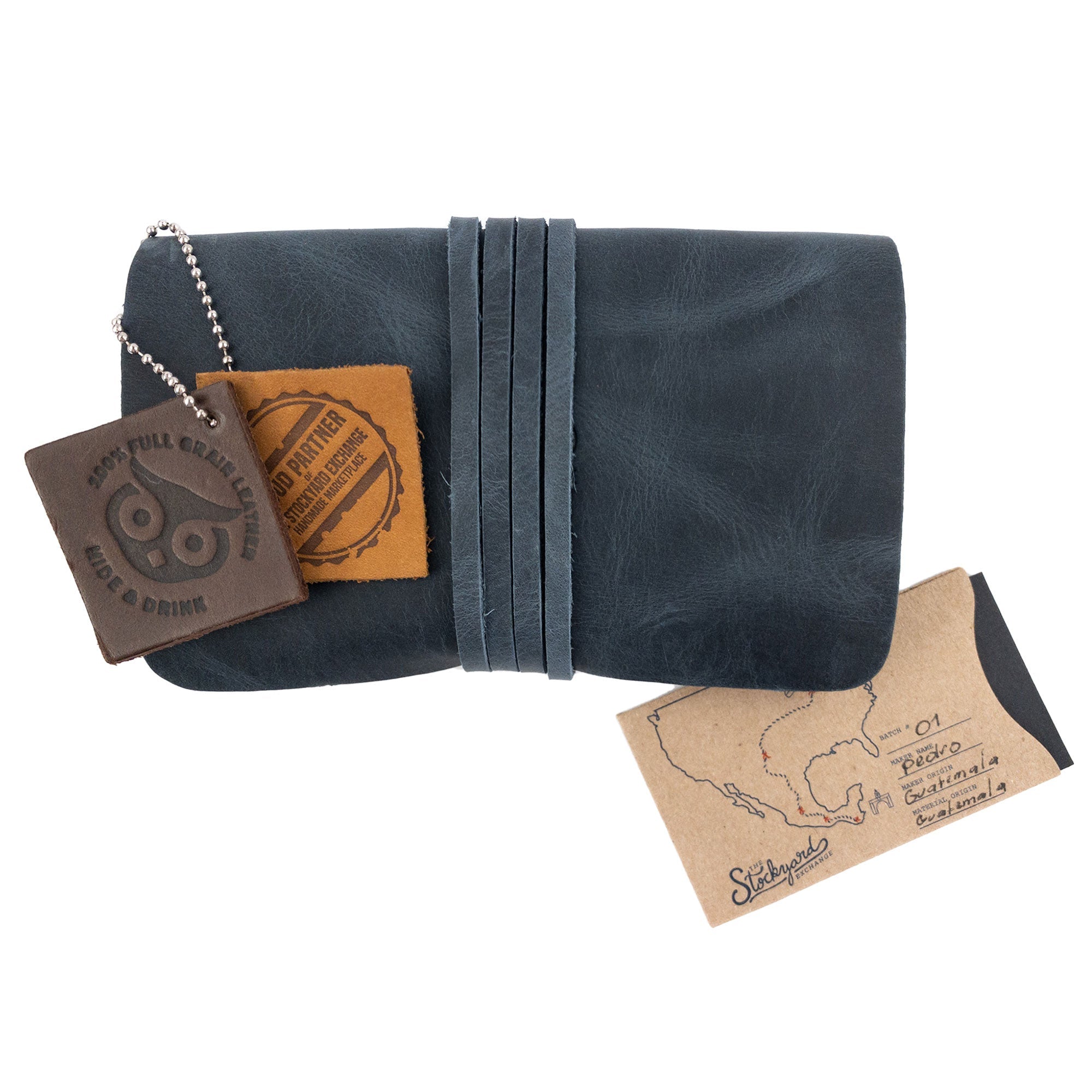 Hide & Drink's King Size Tobacco Pouch, elegantly wrapped, featuring intricate details and tags emphasizing its vintage charm and small batch production from La Antigua Guatemala.