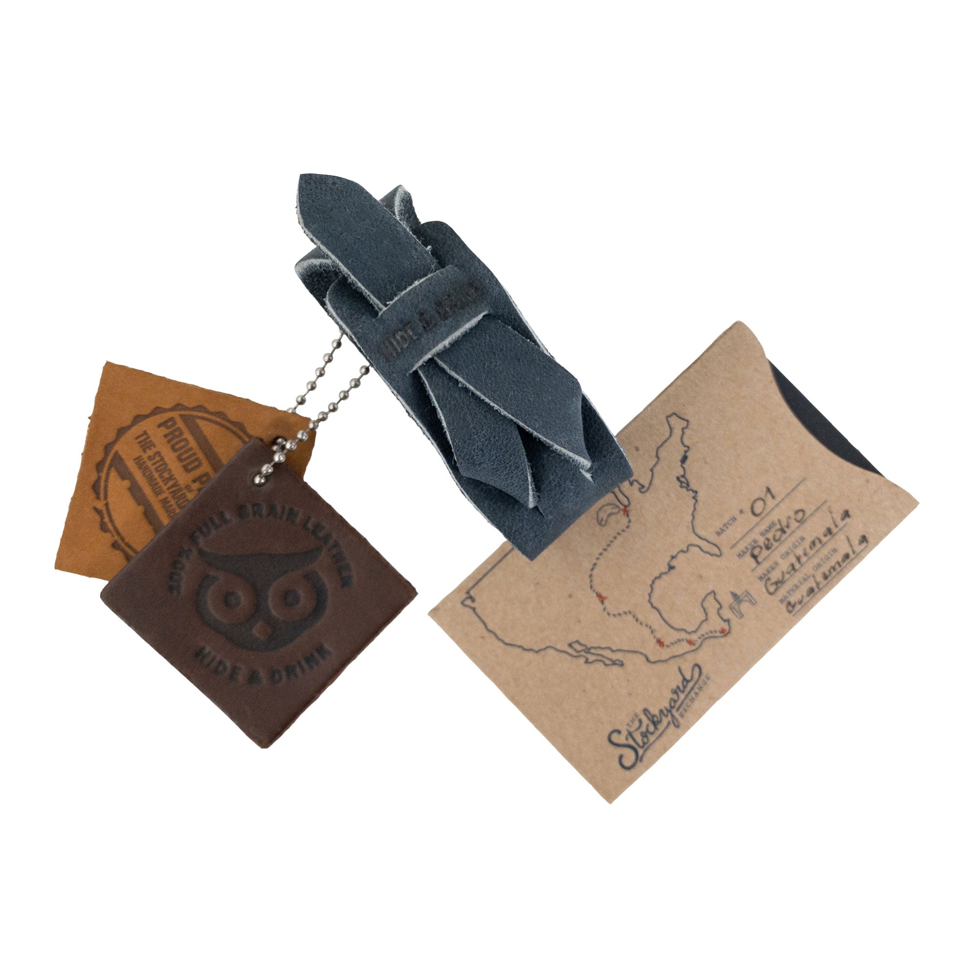 Hide & Drink's Minimalist Wristband showcasing artisan tags emphasizing its full grain leather quality. This navy rustic bracelet features an adjustable design and is handmade in La Antigua Guatemala, displaying StockyardX's dedication to craftsmanship.