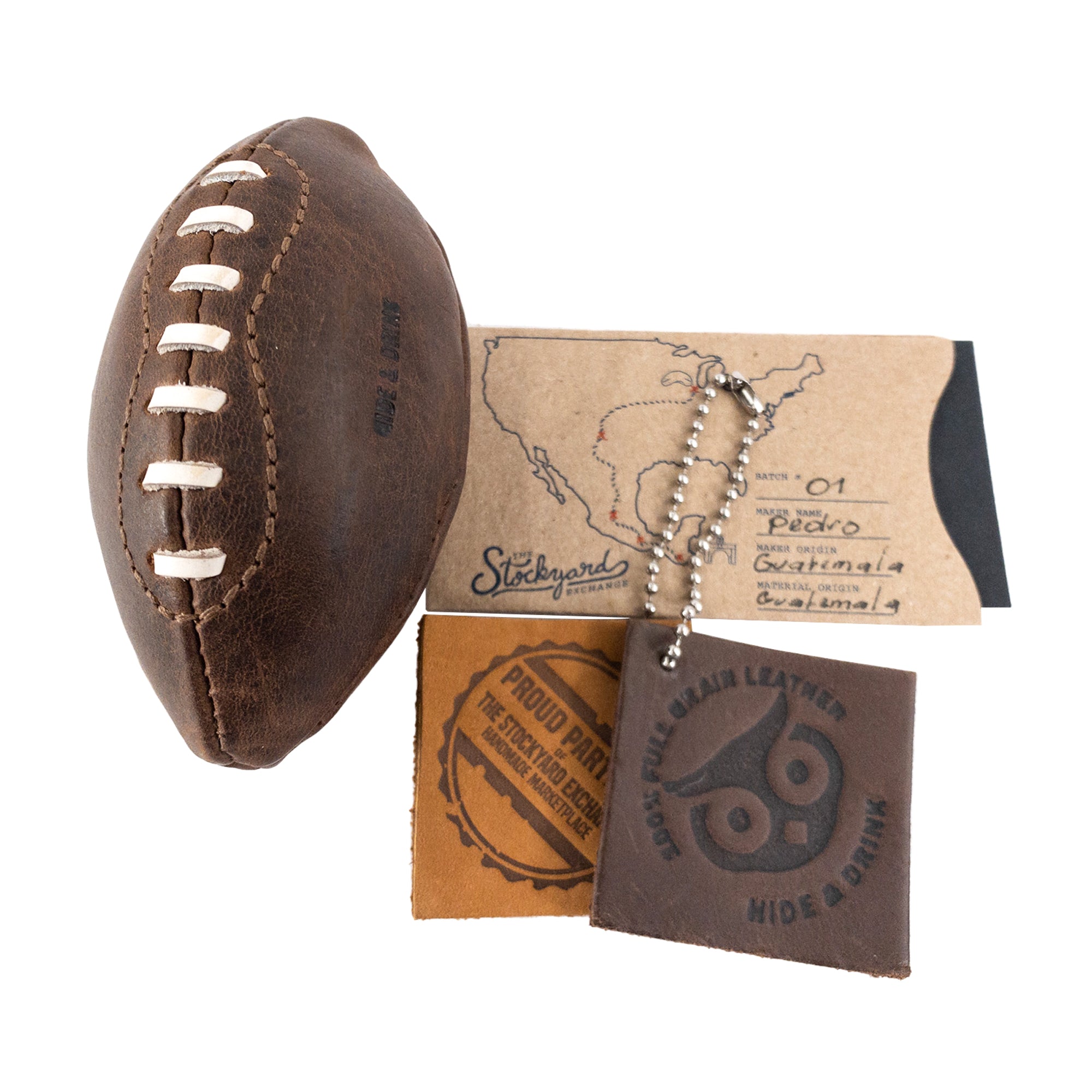 Mini American Football by Hide & Drink along with care cards showcasing its artisan heritage. This hand stitched ball is made from full grain leather, perfect as a keepsake or decorative piece, highlighting the unique craftsmanship from La Antigua Guatemala & Oaxaca Mexico.