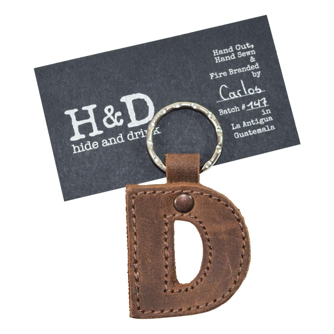 Unique 'D' thick leather Alphabet Letter Keychain from Hide & Drink, showcasing markings from artisan production. Ideal for keyring personalization, handcrafted in La Antigua Guatemala.