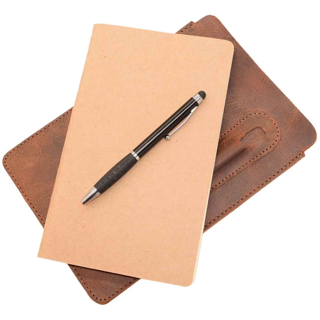 A close-up of Hide & Drink's Notebook Sleeve & Pen Holder (5 x 8.5 in.) (Notebook Not Included), featuring a pen beside a blank notebook, made from durable full grain leather, ideal for anyone seeking a stylish journal cover or diary case, crafted artisanally in La Antigua Guatemala.