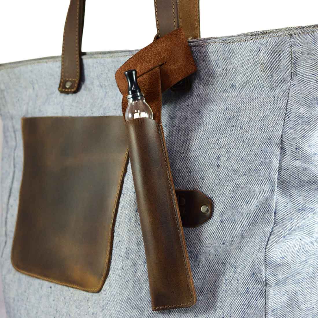 Hide & Drink Vape Pen Holder attached to a bag, showcasing its functionality as a Pen Holder for Handbags. This elegant Hanging Pen Case for Tote Bag is made from durable full grain leather, highlighting the craftsmanship of small batch production and artisan techniques, hand cut and hand sewn with fire branded details.