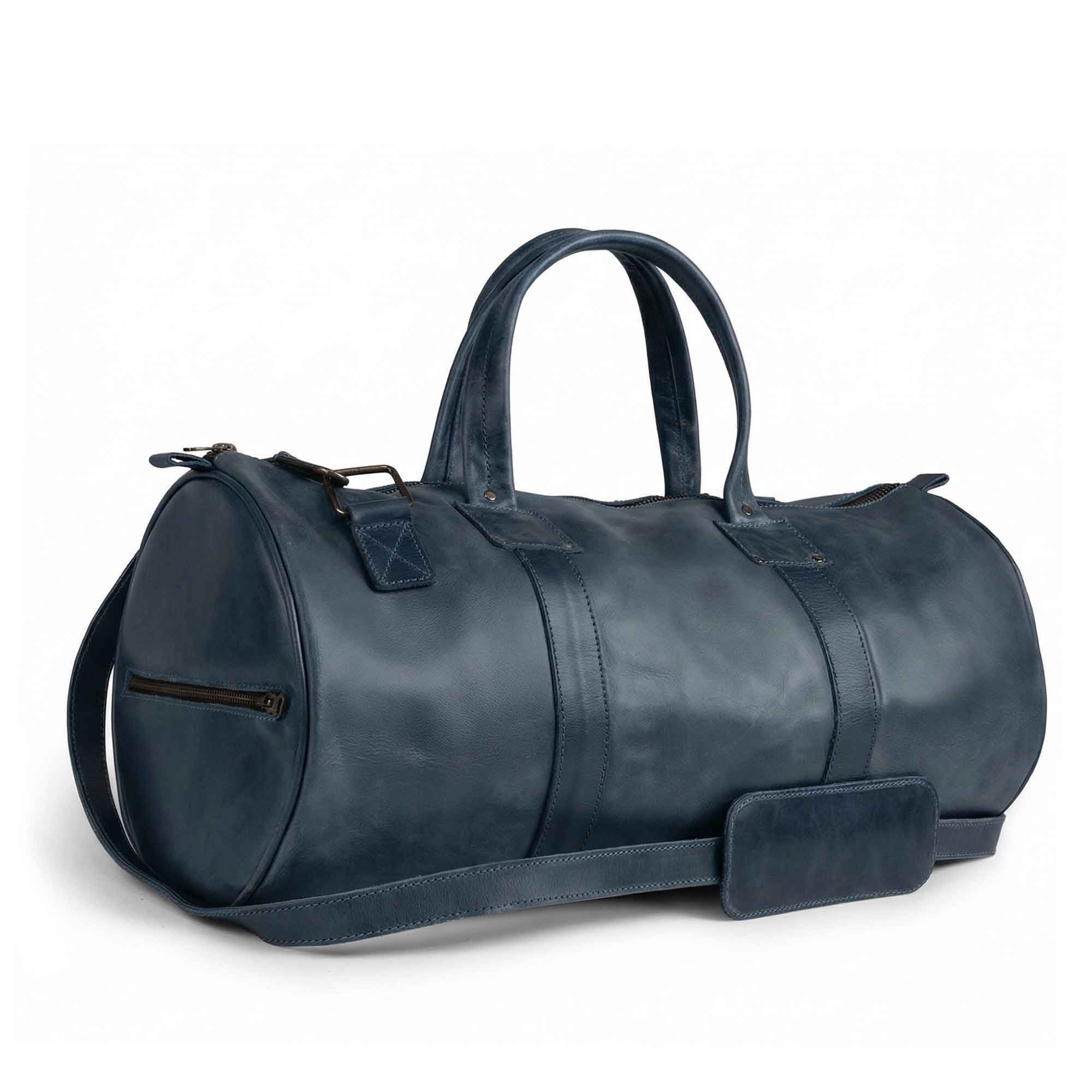 Top view of the Classic Duffle Bag by Hide & Drink in dark brown leather, emphasizing spacious interior and handy design with adjustable strap and zipper closure. This Full Grain Leather Classic Duffle Bag is a timeless Messenger Bag for your travels, handmade in La Antigua Guatemala & Oaxaca Mexico.