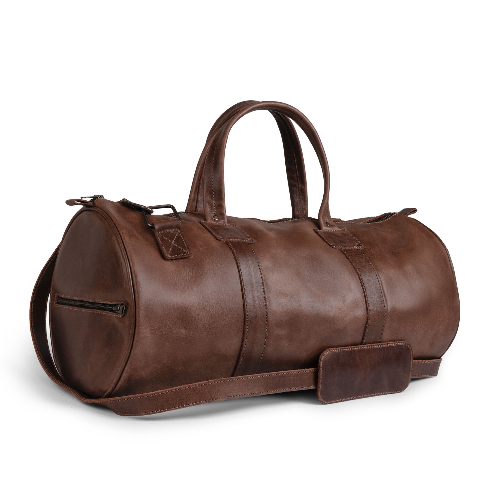 Classic Duffle Bag by Hide & Drink, showcasing a rich Full Grain Leather design with an adjustable strap and zipper closure. This stylish Messenger Bag serves as a perfect crossbody travel bag, reflecting Small Batch Production craftsmanship, hand-cut and hand-sewn by artisans in La Antigua Guatemala & Oaxaca Mexico.