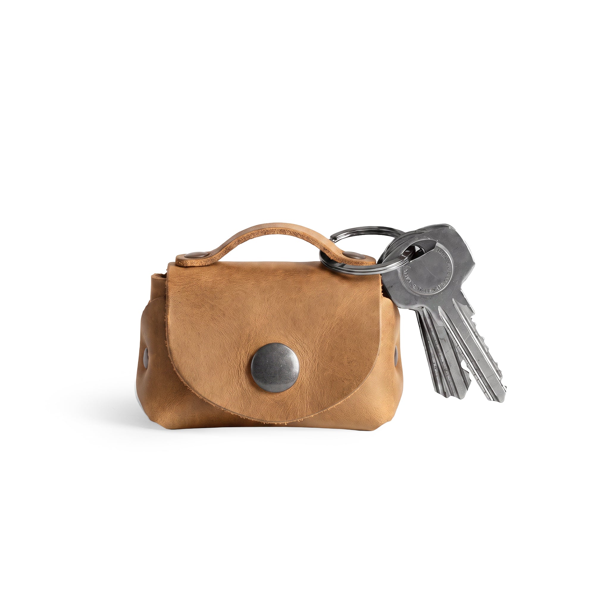 Tiny Handbag Keychain in light brown leather, featuring a unique design with a key ring holder by Hide & Drink. This elegant Tiny Handbag with Key Ring Holder is made from full grain leather and highlights the values of small batch production, hand cut, hand sewn, and fire branded detailing, carefully crafted by artisans in La Antigua Guatemala & Oaxaca Mexico.