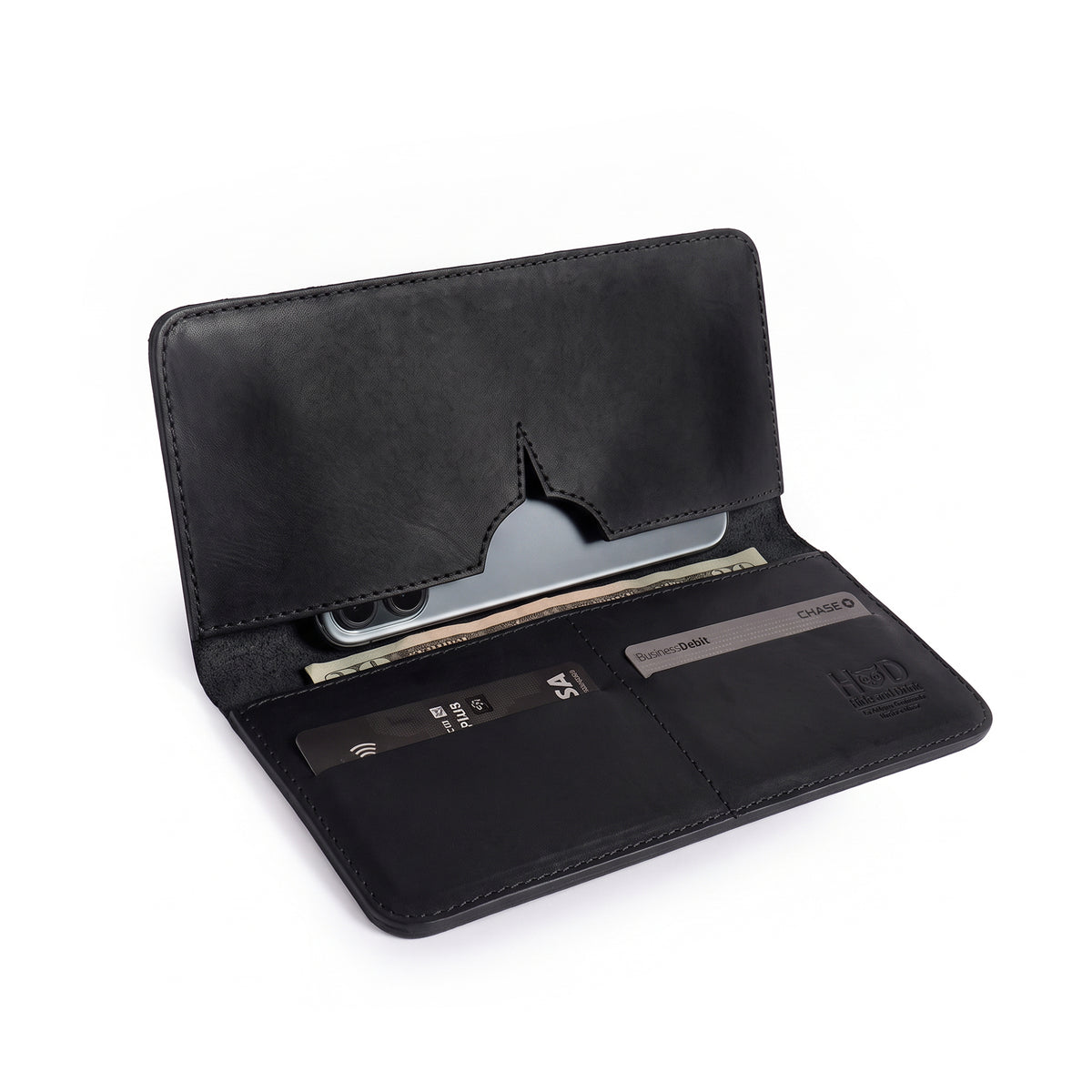 Open black bifold wallet for cellphone by Hide & Drink, displaying card slots and cash compartment. This Bifold Wallet for Cellphone pairs premium Full Grain Leather with ideal organization features. Handcrafted with care in small batches by artisans in La Antigua Guatemala & Oaxaca Mexico.