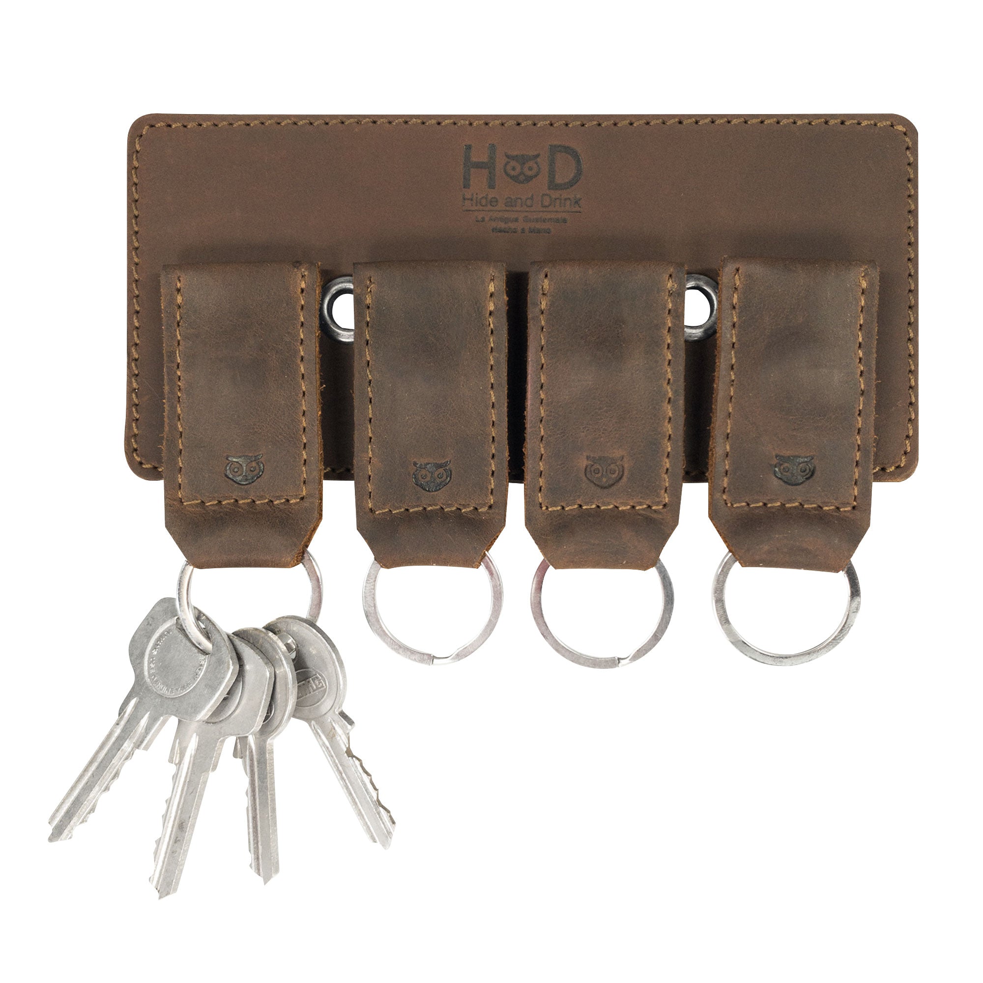 A rustic Magnetic Keychain Holder by Hide & Drink showcasing a handmade design that features multiple key rings for organization. Made from durable full grain leather, this key ring organizer combines style and utility as a wall decor accessory. Enjoy its artisan craftsmanship from small batch production in La Antigua Guatemala & Oaxaca Mexico.