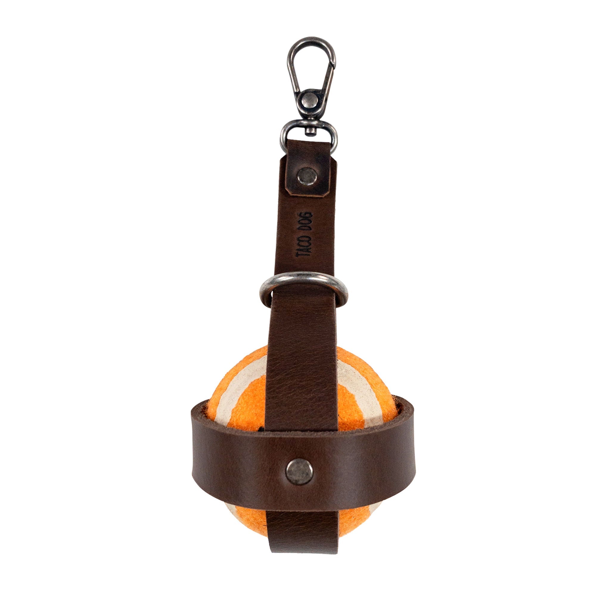 Taco Dog Dog Ball Holder featuring a vibrant orange ball securely held with a sturdy leather strap and metal hook, perfect for outdoor adventures. This Leash Attachment Case provides reliable Chasing Pet Toy Storage made from Full Grain Leather. Handmade in La Antigua Guatemala, this alluring accessory showcases a commitment to Small Batch Production.