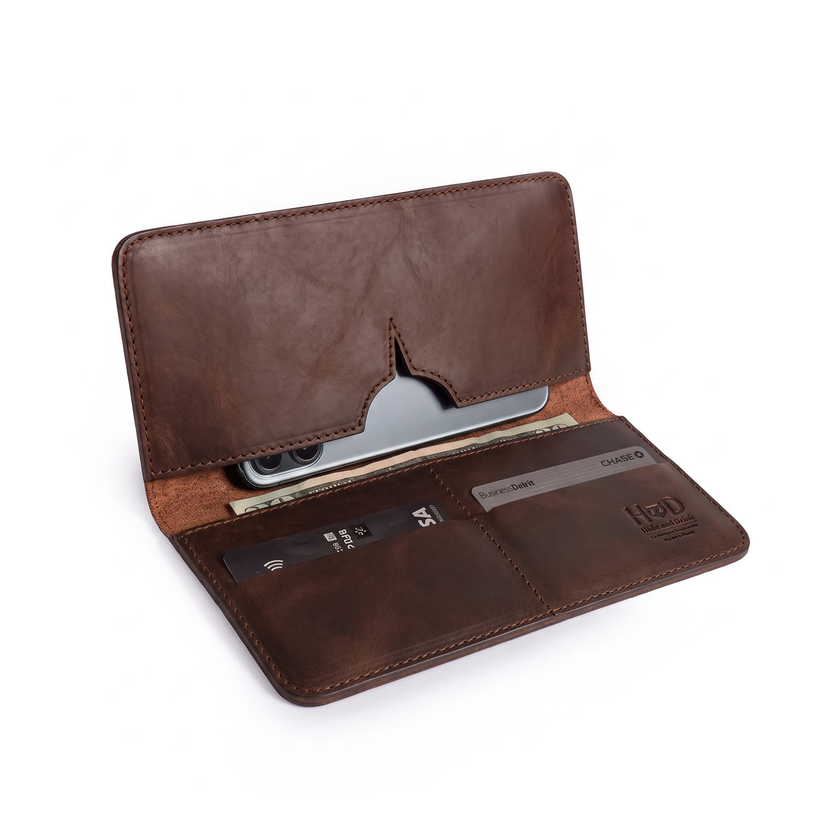 Open bifold wallet for cellphone by Hide & Drink, showcasing compartments for cards and a sleek design. This Bifold Wallet for Cellphone is made from Full Grain Leather, perfect for keeping your essentials organized. Enjoy the high-quality craftsmanship with features like small batch production and handmade in La Antigua Guatemala & Oaxaca Mexico.