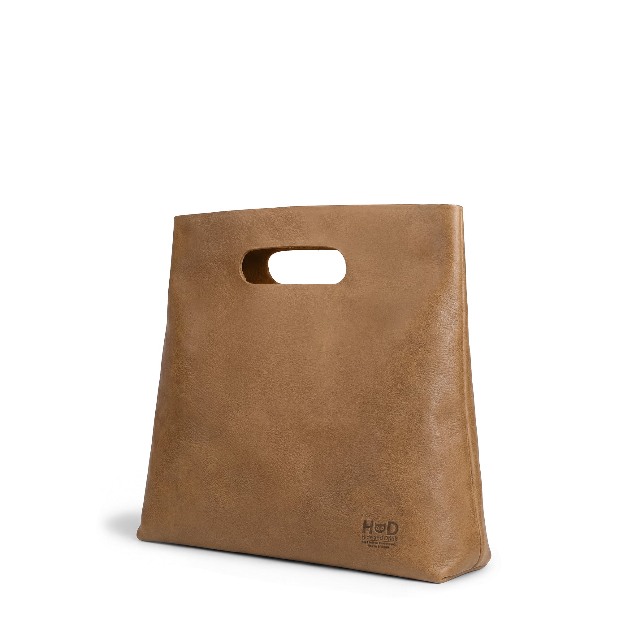 Side view of the brown Minimalist Boho Handbag by Hide & Drink, highlighting its sleek silhouette. This Minimalist Handbag for Women is great as a Tote Bag crafted from Full Grain Leather, showcasing exquisite artisan craftsmanship.
