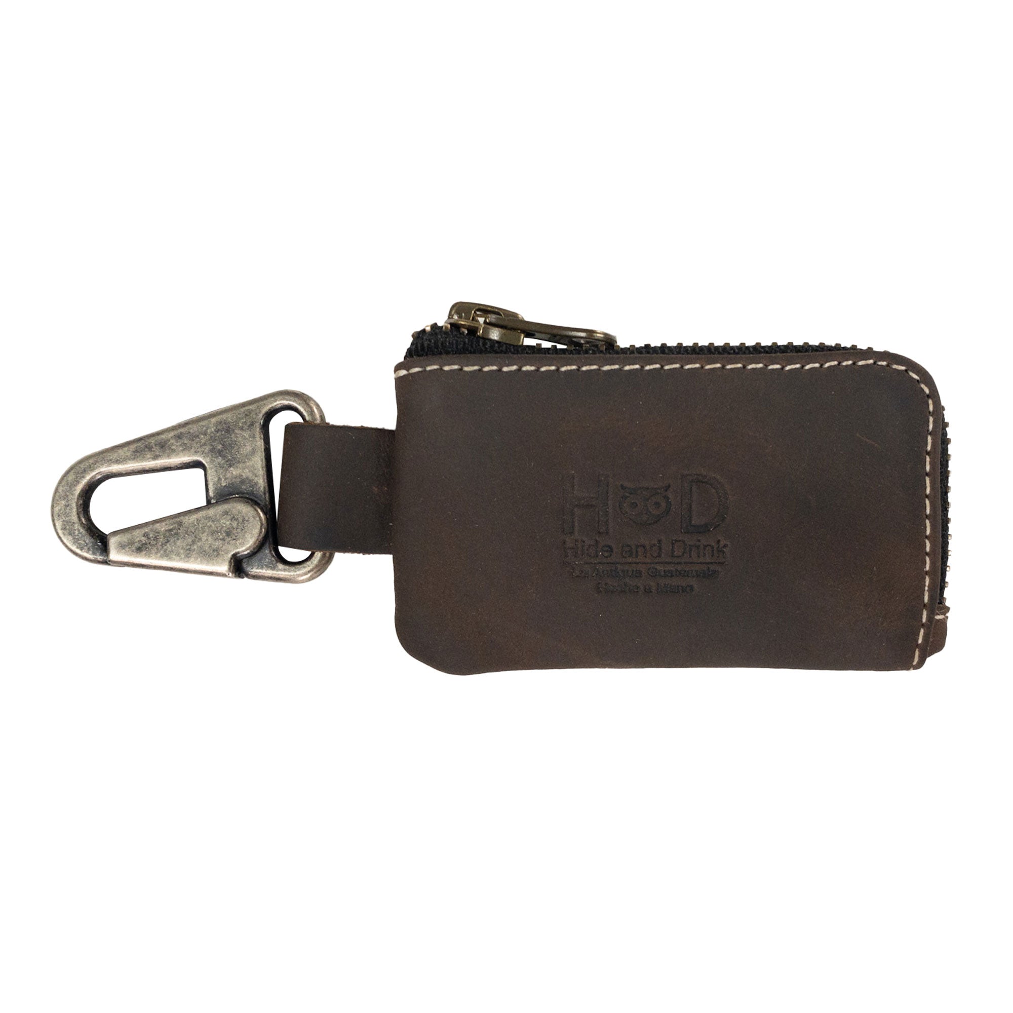 Car Key Holder by Hide & Drink in a chic brown design, perfect for holding keys and cash along with multifunctionality for Headphone and charging Cables, Memory Cards, and Flash Drives. Crafted from high-quality Full Grain Leather with a Nickel Metal Clasp, showcasing artisan craftsmanship from Small Batch Production in La Antigua Guatemala & Oaxaca Mexico.