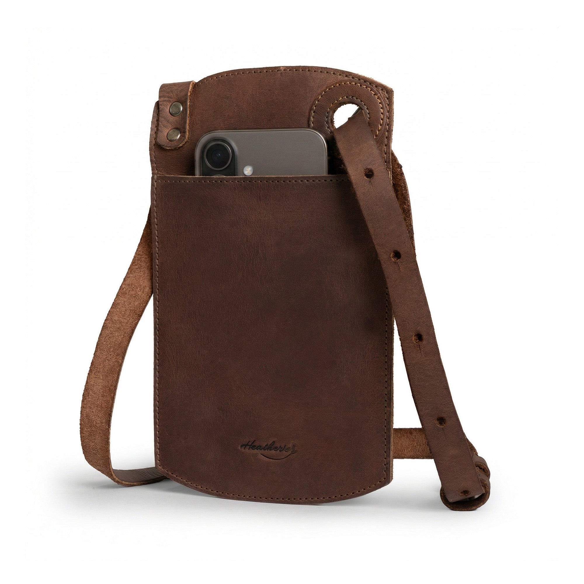 View of a Phone Purse with Adjustable Strap by Heather's, showcasing a durable and stylish design in full grain leather. Features a horizontal cellphone bag with an adjustable neck strap and card slot, perfect as a crossbody bag or mini messenger bag. Handmade in La Antigua Guatemala, this small batch production item is hand cut and sewn, offering artisan quality.