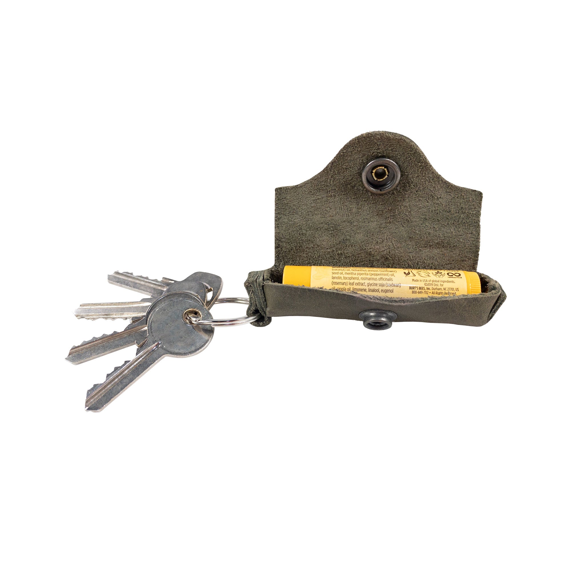 Handcrafted Lip Balm Key Chain from Hide & Drink securely holding a lip balm with keys attached. This classic vintage design features a brass metal clasp and is made of full grain leather, offering excellent lip protection. Perfect for carrying around, this Lip Balm Key Chain is a great accessory for anyone who values artisan craftsmanship, handmade in La Antigua Guatemala & Oaxaca Mexico.