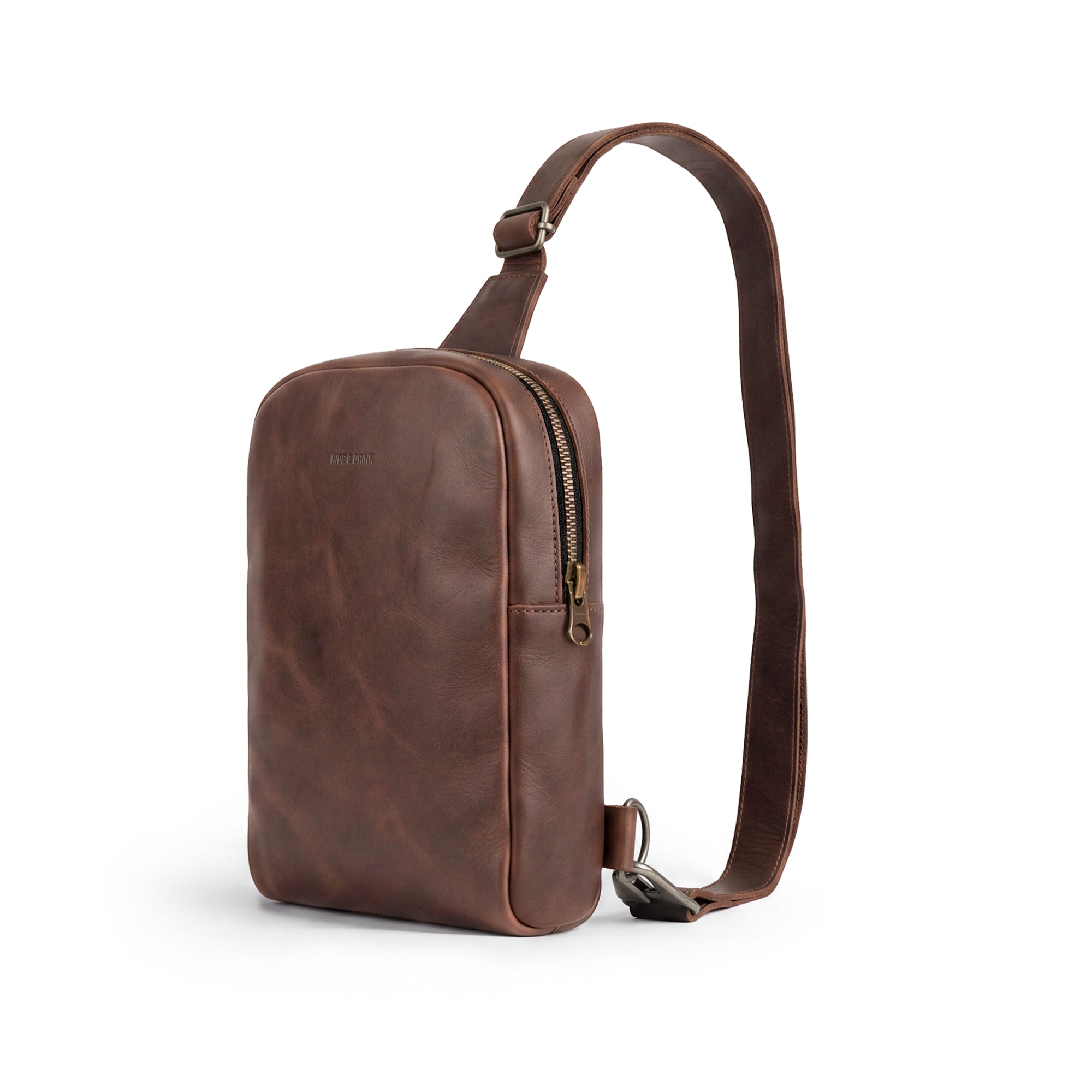 Showcasing the Hide & Drink Crossbody Rounded Bag filled with essentials, this Rounded Crossbody Bag with Adjustable Strap is perfect for travel. Made from Full Grain Leather, it's an artisan piece with small batch production details, hand cut and hand sewn, showcasing the craftsmanship of handmade items from La Antigua Guatemala & Oaxaca Mexico.