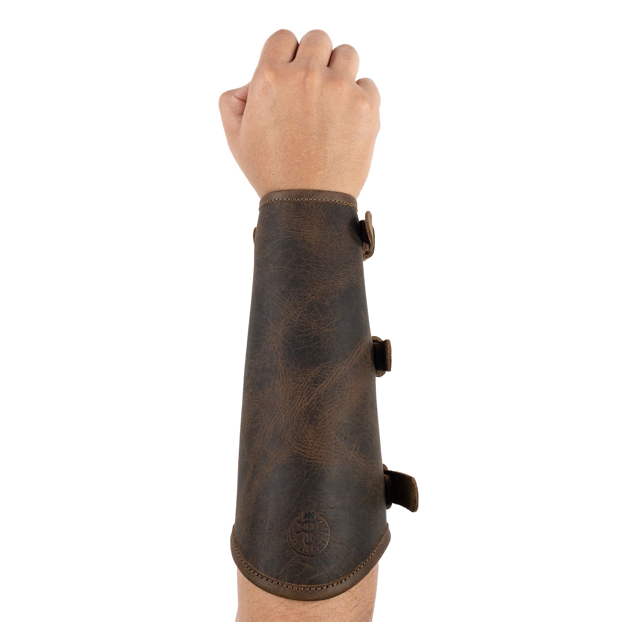 Hand model showcasing the Rustic Archery Bracer by Valhalla Gear, featuring adjustable buckle straps made from durable full grain leather. This forearm protector is perfect for knights and cosplay events. It combines artisan craftsmanship with small batch production, ensuring each piece is handmade in La Antigua Guatemala & Oaxaca Mexico.