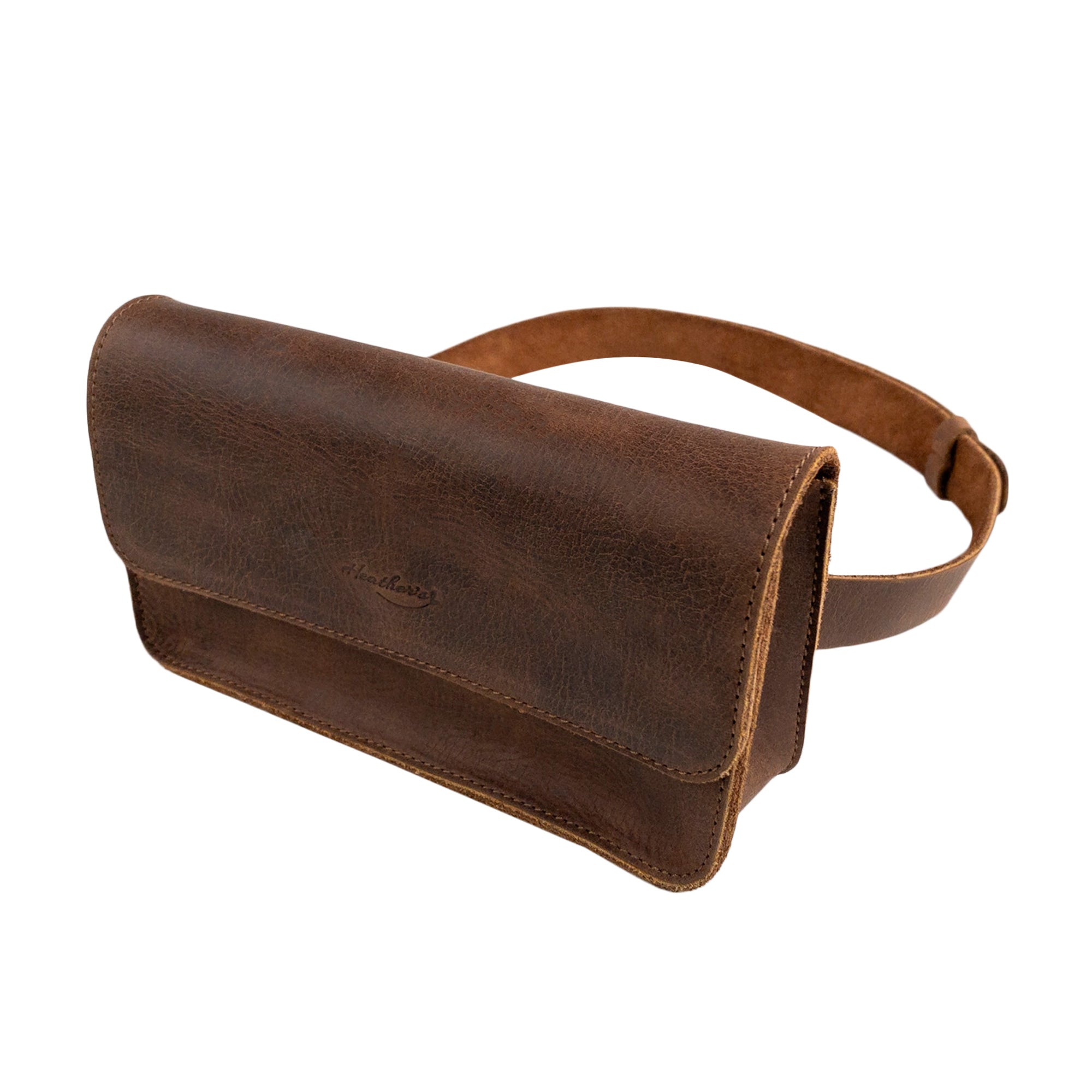 Heather's Rectangular Fanny Pack showcases a vintage design crafted from full grain leather, making it a stylish and durable accessory for women. This hip bag with an adjustable strap is perfect for hands-free convenience. Features include small batch production, artisan craftsmanship, and is handmade in La Antigua Guatemala & Oaxaca Mexico.