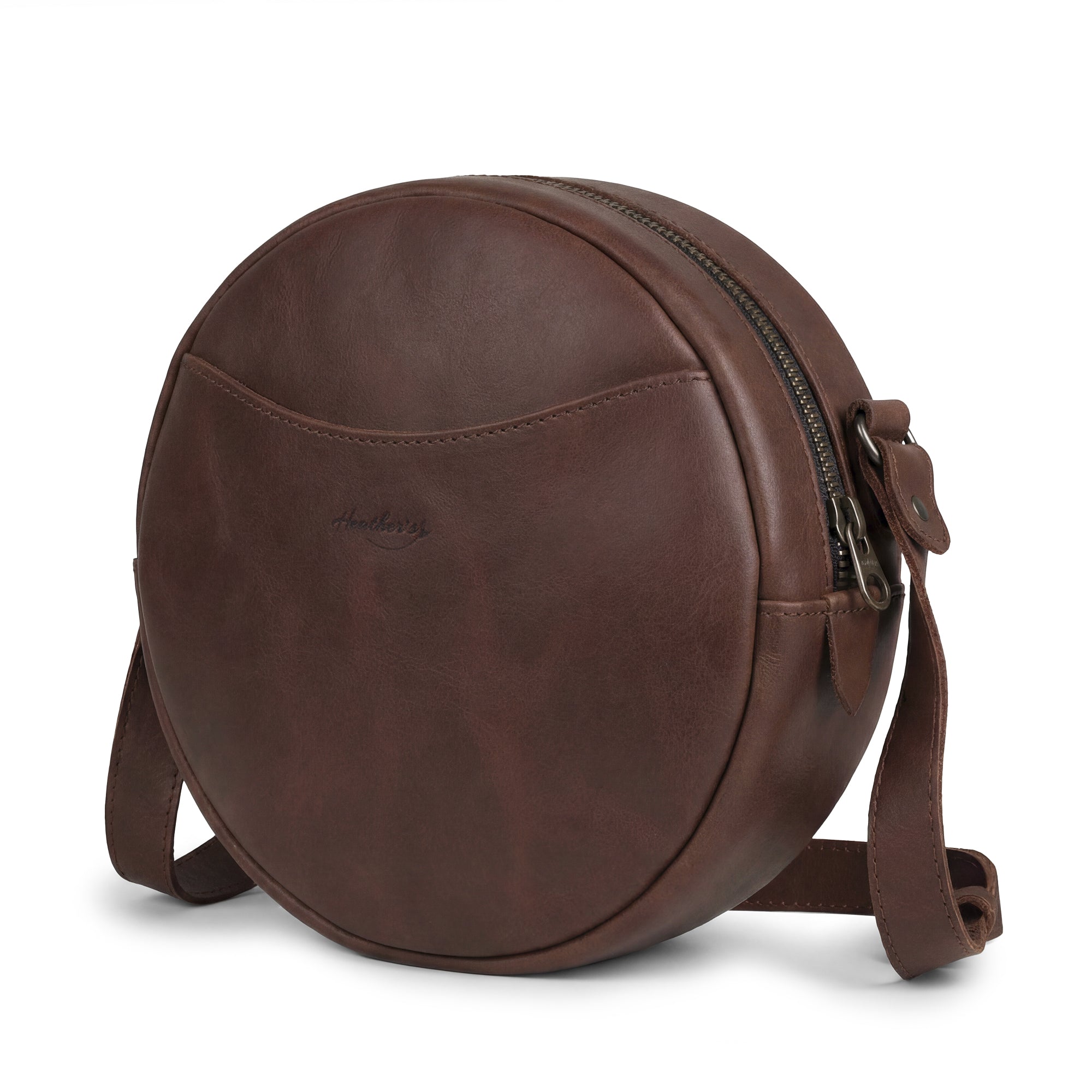 Heather's Female Rounded Crossbody Hand Bag made of Full Grain Leather, featuring a stylish design perfect for any occasion. This Rounded Crossbody bag for women is a zippered handbag that combines fashion and functionality. Handmade in La Antigua Guatemala, it showcases small batch production with hand cut and hand sewn details, proudly fire branded by artisans.