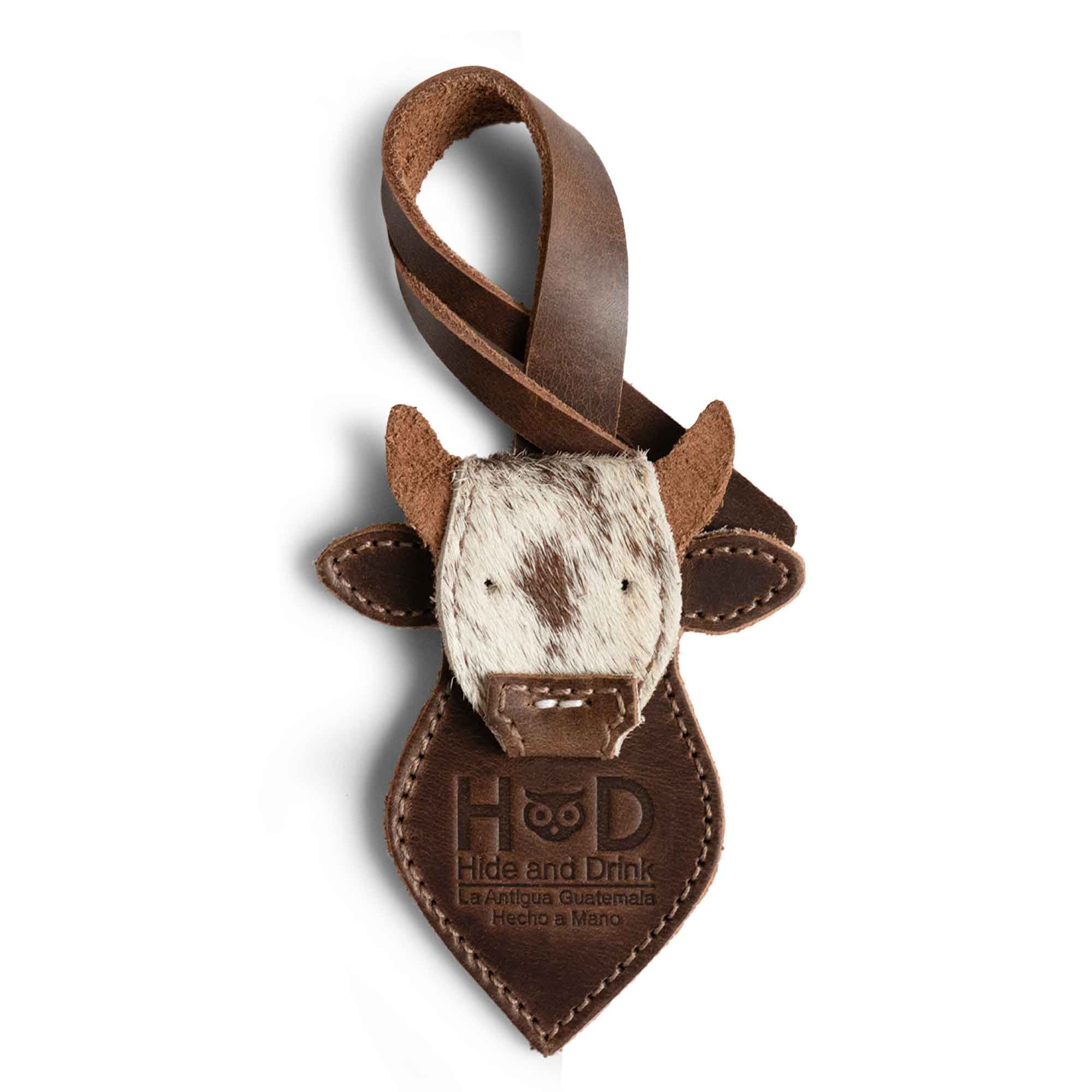 Hide & Drink Bag Charms featuring a cow head design, a stylish charm for handbags. This accessory makes a great purse charm for tote & backpacks, crafted from full grain leather. Each piece is a testament to StockyardX's small batch production, showcasing hand cut and hand sewn artistry with fire branding, handmade in La Antigua Guatemala & Oaxaca Mexico.