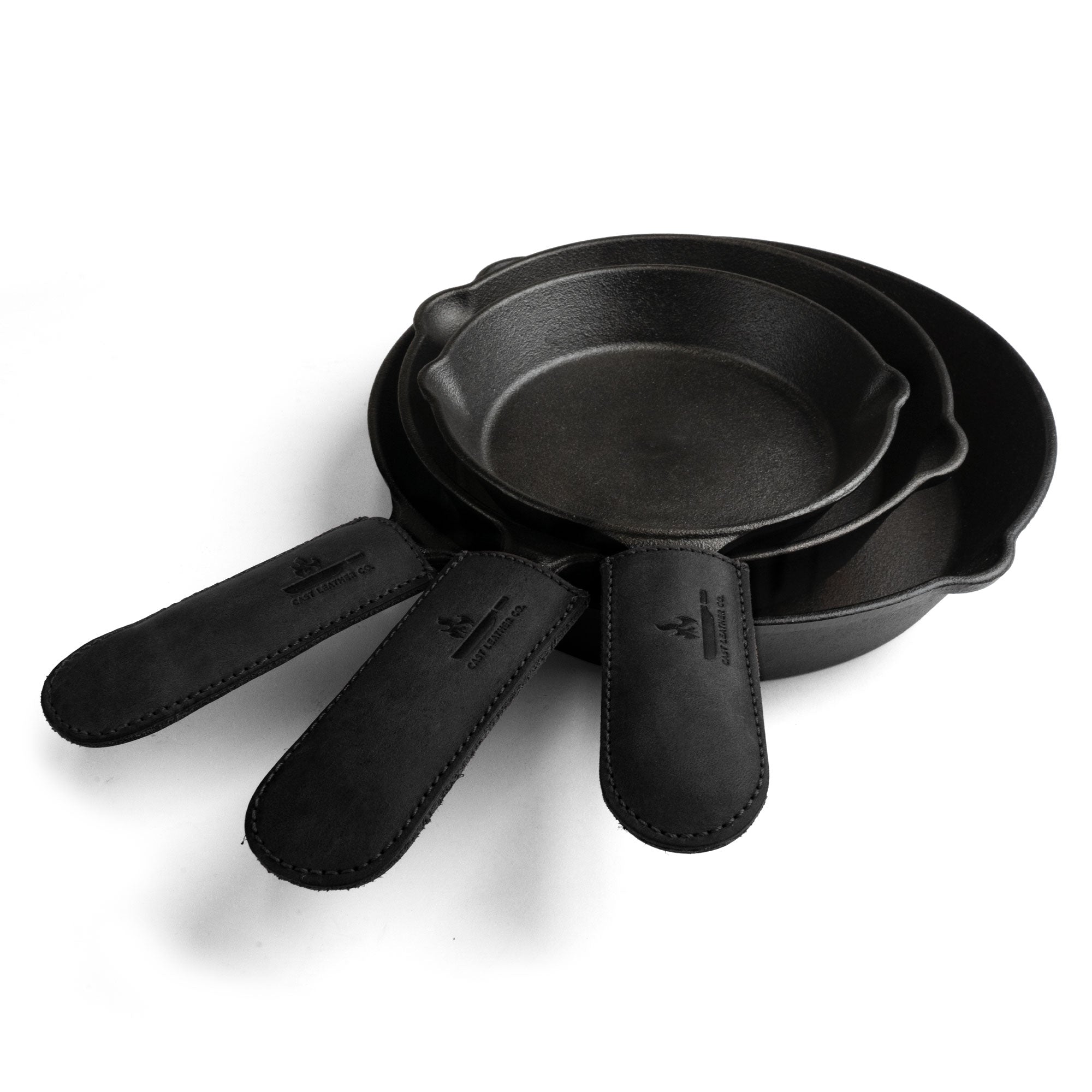 A striking black version of Cast Leather Co.'s Hot Handle Covers (Set of 3), designed for cast iron skillets with heat-resistant properties. These artisan skillet handle covers are handmade in La Antigua Guatemala and Oaxaca Mexico, showcasing superb craftsmanship.