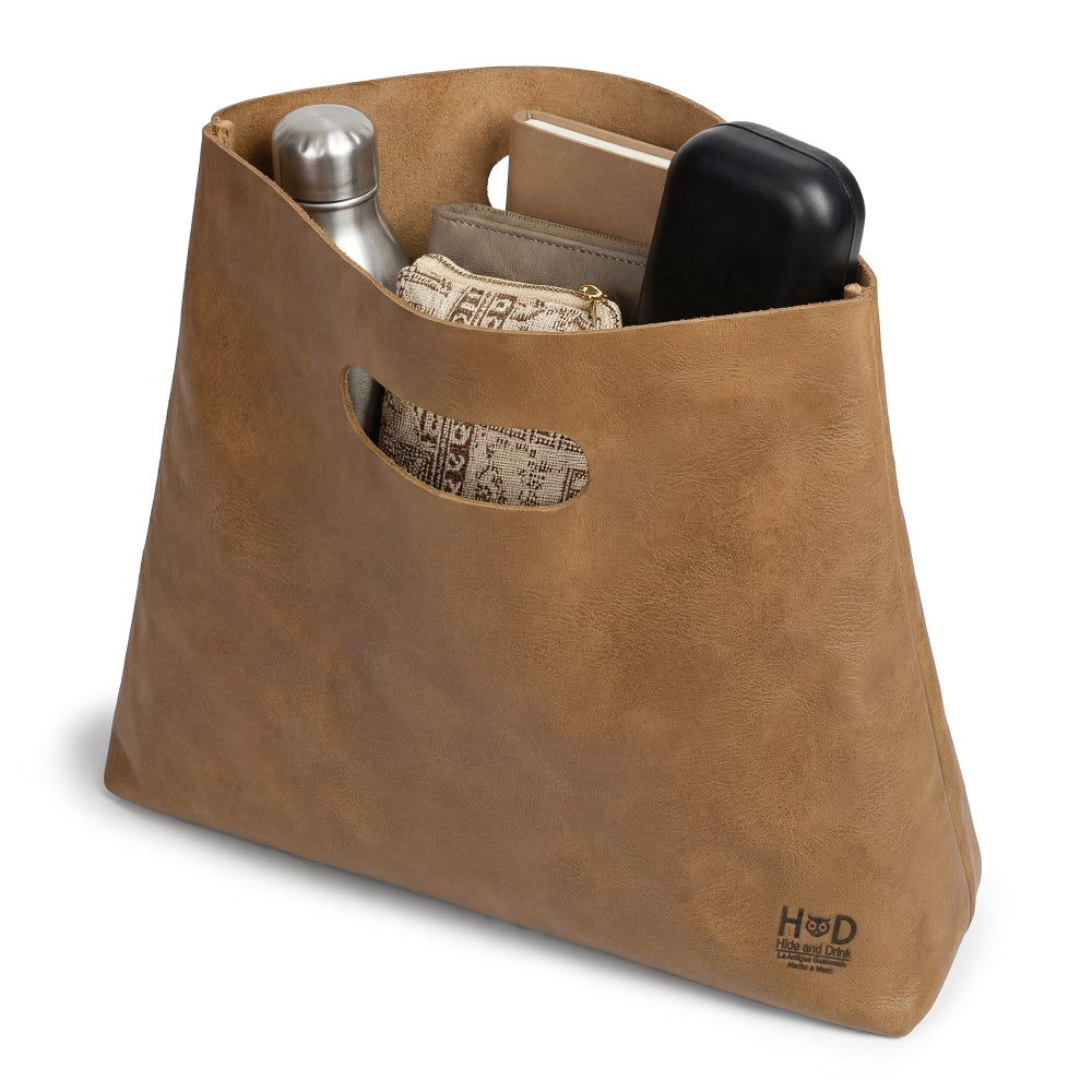 The Minimalist Boho Handbag by Hide & Drink filled with items, showcasing its spacious interior. This functional and stylish Minimalist Handbag for Women is ideal as a Rustic Purse or Tote Bag, featuring the artisanal quality of Full Grain Leather.