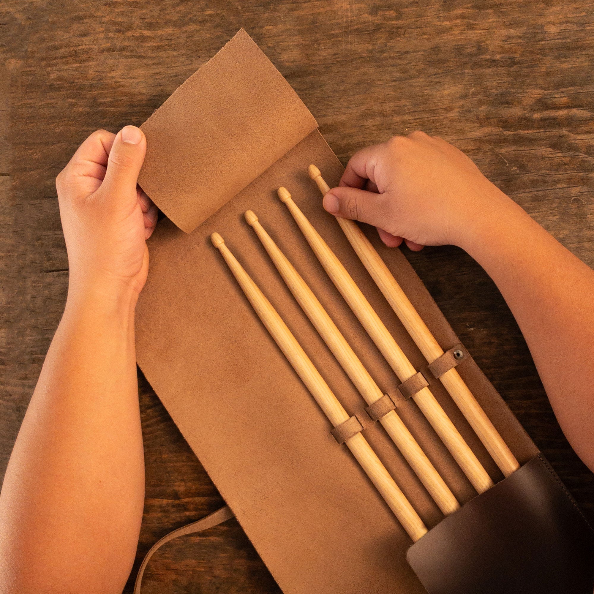 Close-up of the Drum Stick Roll by tocame, illustrating how to neatly store drumsticks. This Drum Stick Roll provides a great solution for drummers looking for a Full Grain Leather accessory that is both stylish and practical. Each piece is handmade by artisans, ensuring quality and uniqueness.