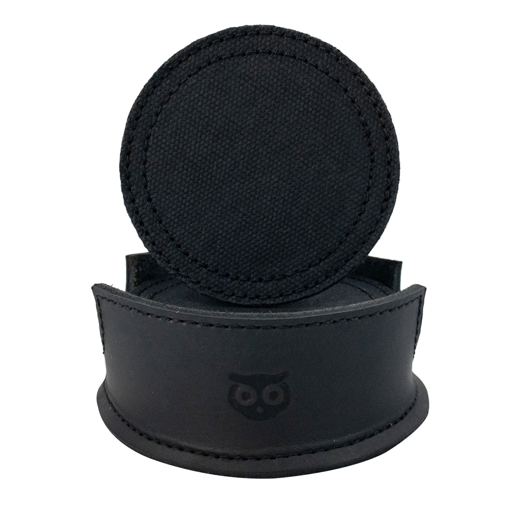 A single circular coaster displayed on a leather holder, from the Set of 8 Circular Coasters for Drinks by Hide & Drink. This handmade piece from Waxed Canvas and Full Grain Leather provides Glass & Cups Stain Protection. Discover the craftsmanship of StockyardX through these Small Batch Production items, which are Hand Cut, Hand Sewn, Fire Branded, and made Artisan, Handmade in La Antigua Guatemala & Oaxaca Mexico.