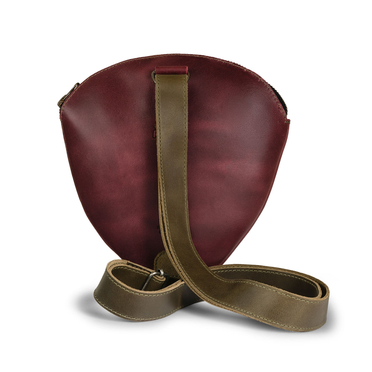 Back view of the Tudi Frudi Strawberry Crossbody, a burgundy Full Grain Leather Strawberry Crossbody Bag with its adjustable shoulder strap laid out behind the bag. The compact Messenger Bag, Shoulder Bag, and Zippered Sling Bags design reflects Full Grain Leather, Small Batch Production, Hand Cut, Hand Sewn, Fire Branded Artisan craftsmanship, Handmade in La Antigua Guatemala & Oaxaca Mexico for StockyardX, and works as a casual Travel Backpack alternative, Satchel, or Purses for Men and Women accessory.
