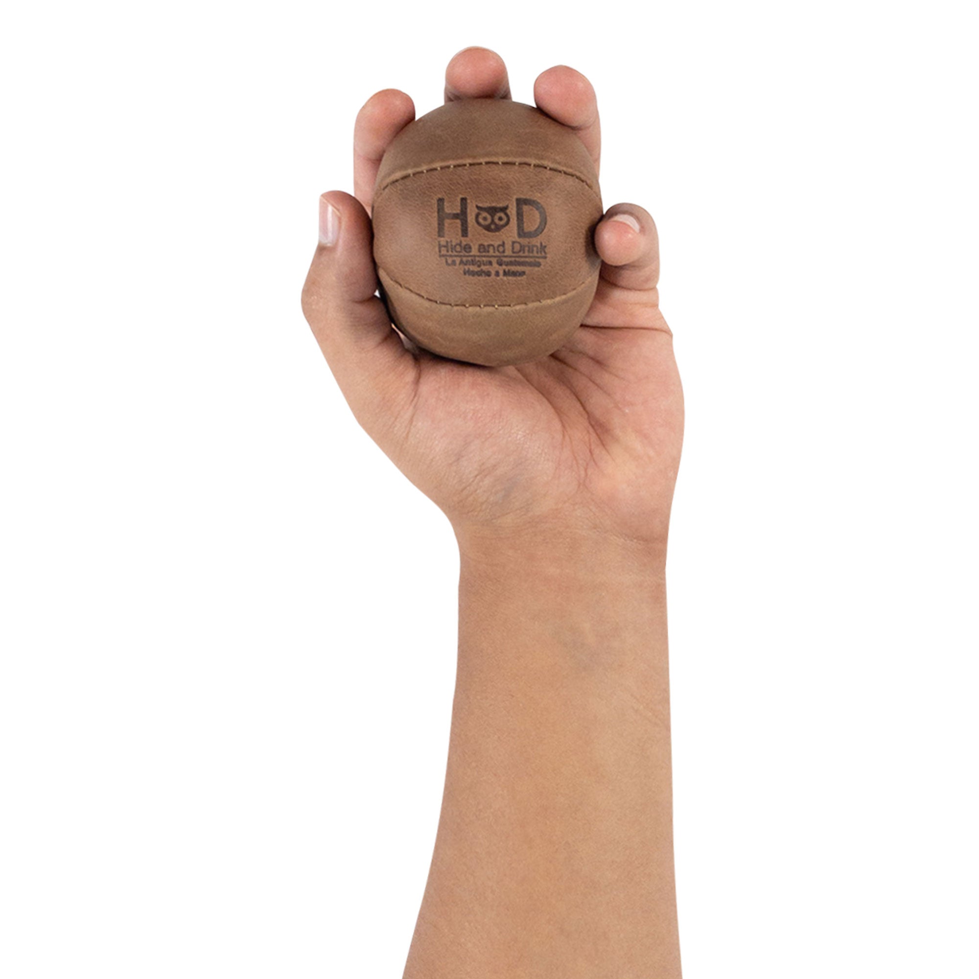 Hide & Drink brown Stress Ball held firmly, a perfect tool to relieve fidgeting and anxiety. This squishy tension accessory highlights classic design and is artisan crafted from full grain leather in La Antigua Guatemala.