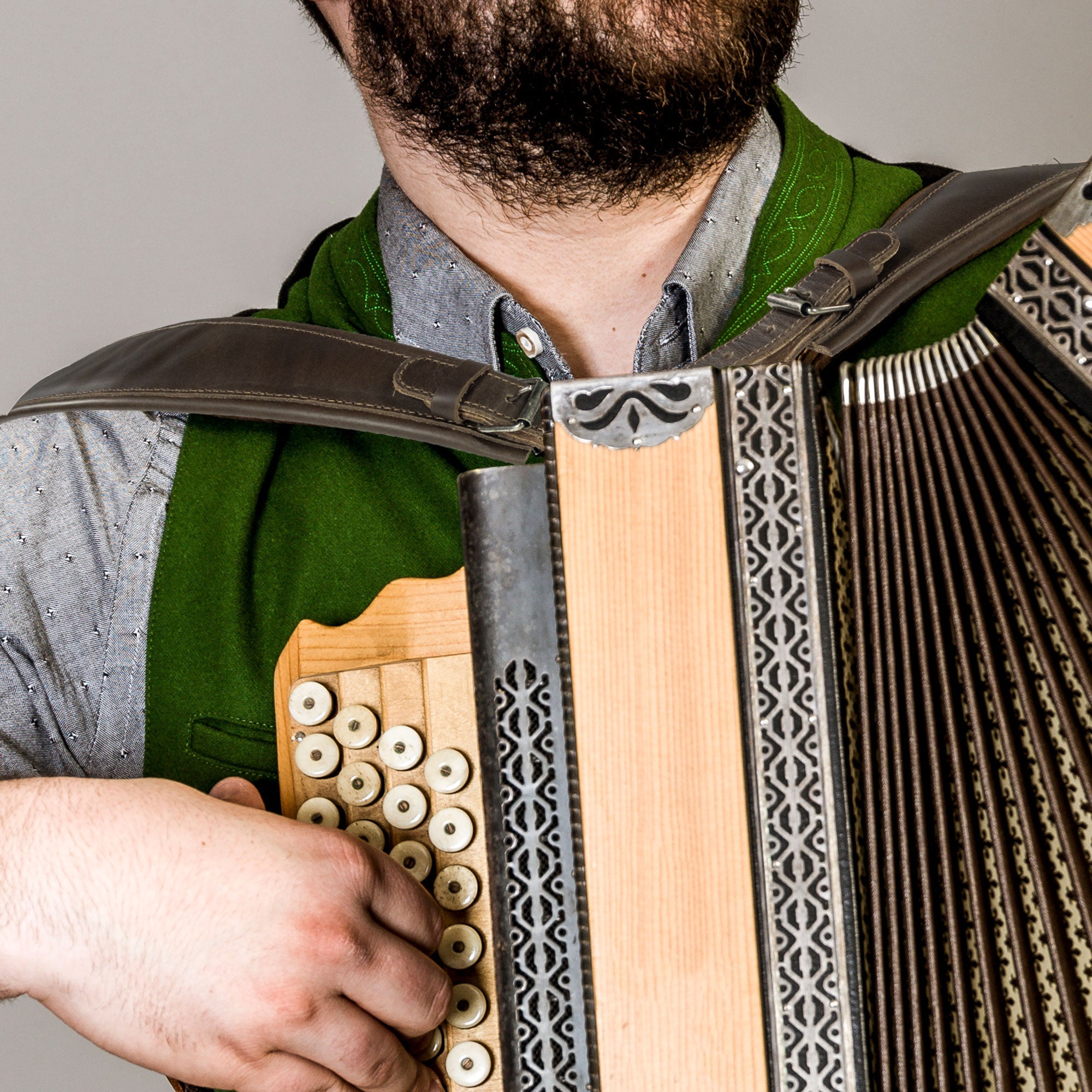 A musician playing an accordion while wearing the Set of 2 Adjustable Padded Straps for Accordion by tocame, highlighting the comfort and support these straps provide. Perfect for all accordion players seeking quality instrument accessories. StockyardX, Small Batch Production, Hand Cut, Hand Sewn, Fire Branded, Artisan, Handmade in La Antigua Guatemala & Oaxaca Mexico.