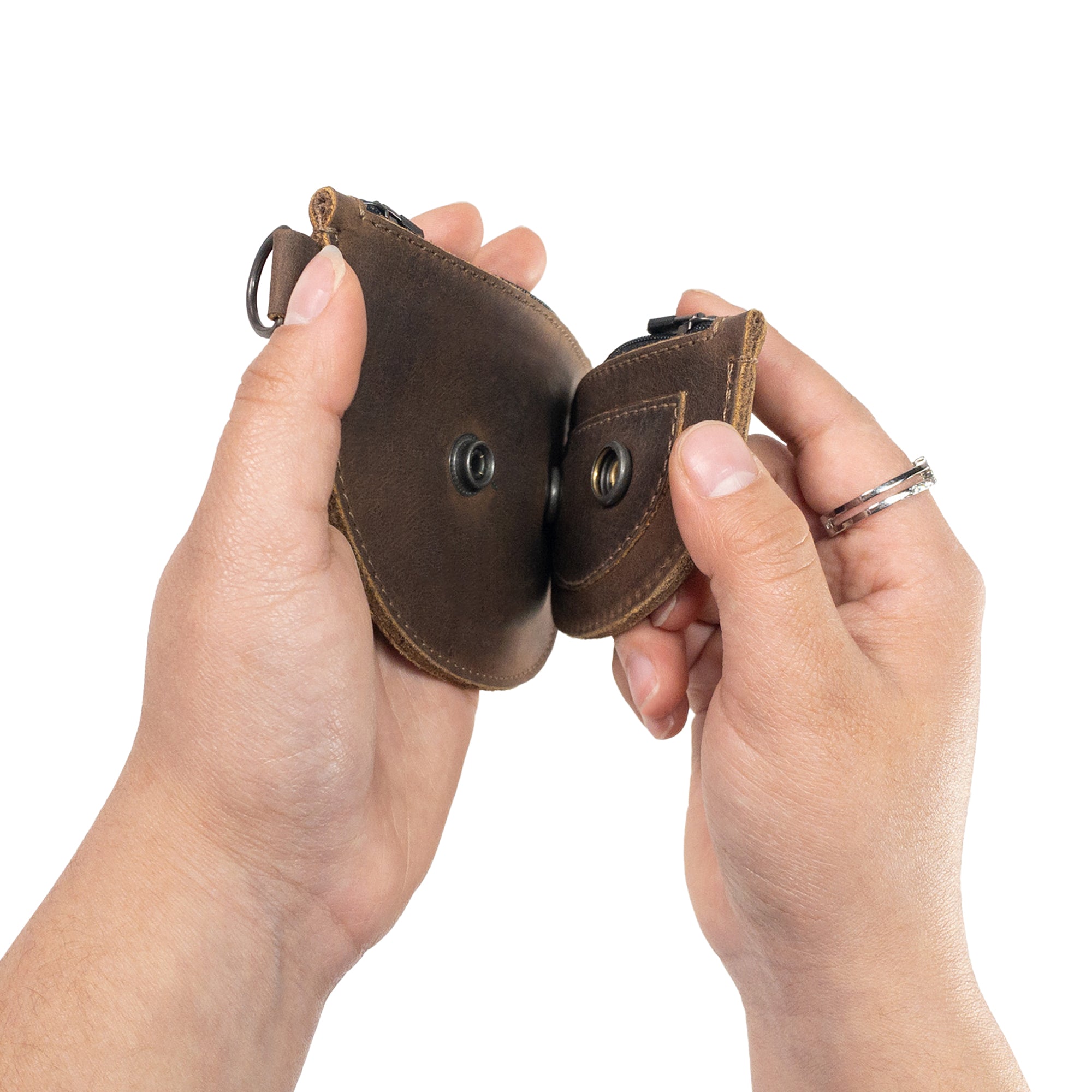 Hands holding Heather's Semi-Circular Double Wallet open, revealing its unique coin pouch and money holder design crafted from Full Grain Leather. This artisan wallet emphasizes hand cut and hand sewn qualities, perfect for modern storage needs.