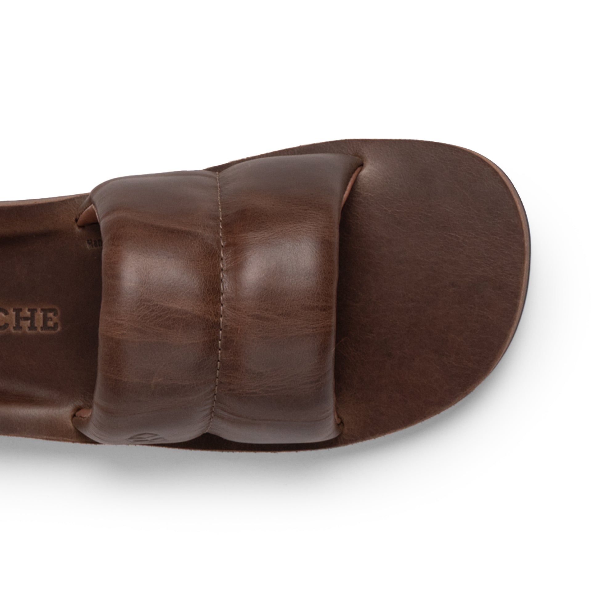 Top view of The Bayside Leather Slide by StockyardX, emphasizing the smooth, rich leather and soft feel. This bayside sandal is designed for comfort and elegance, made of fire branded full grain leather. Artisan-crafted in La Antigua Guatemala & Oaxaca Mexico, it reflects true artisan spirit and handmade quality.
