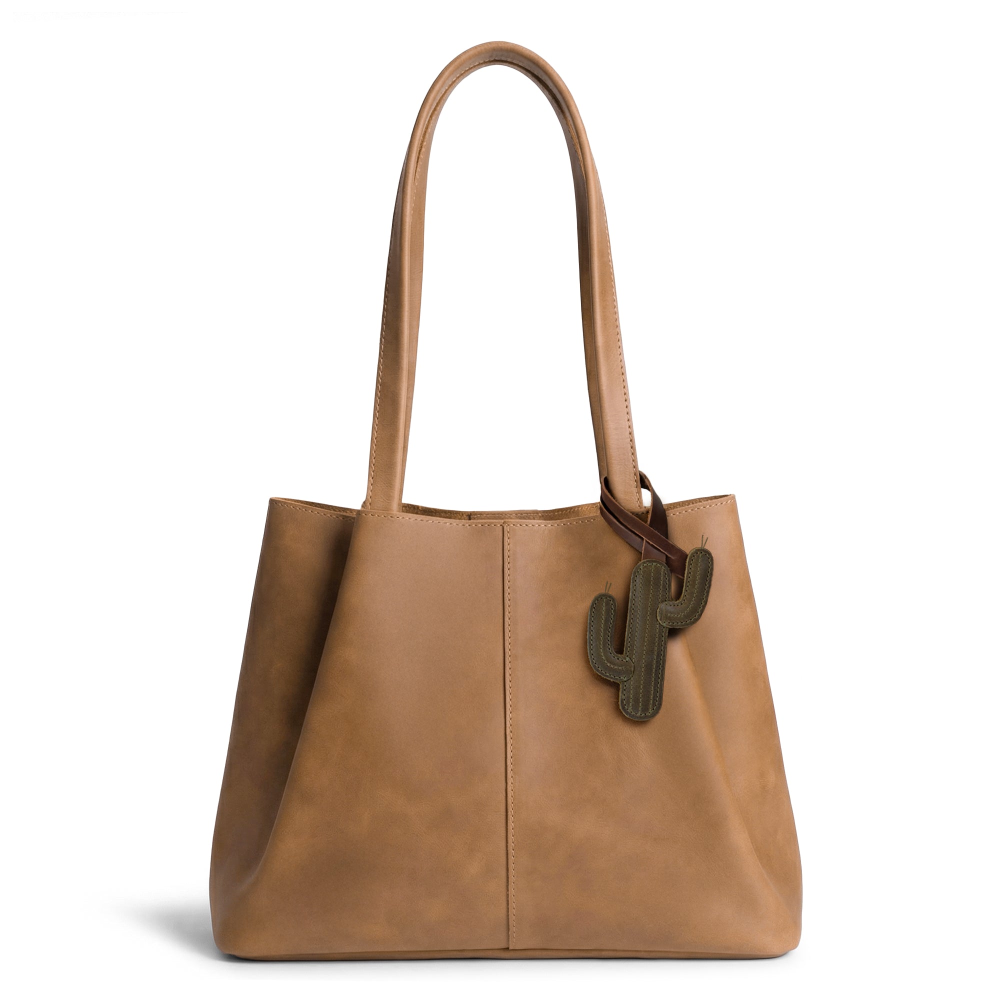 Hide & Drink Bag Charms attached to a trendy brown handbag, displaying a butterfly design ideal for personalization. This accessory serves as a purse charm for tote & backpacks made from high-quality full grain leather, showcasing StockyardX's focus on small batch production. Every piece features hand cut, hand sewn artistry and fire branding, handmade in La Antigua Guatemala & Oaxaca Mexico.