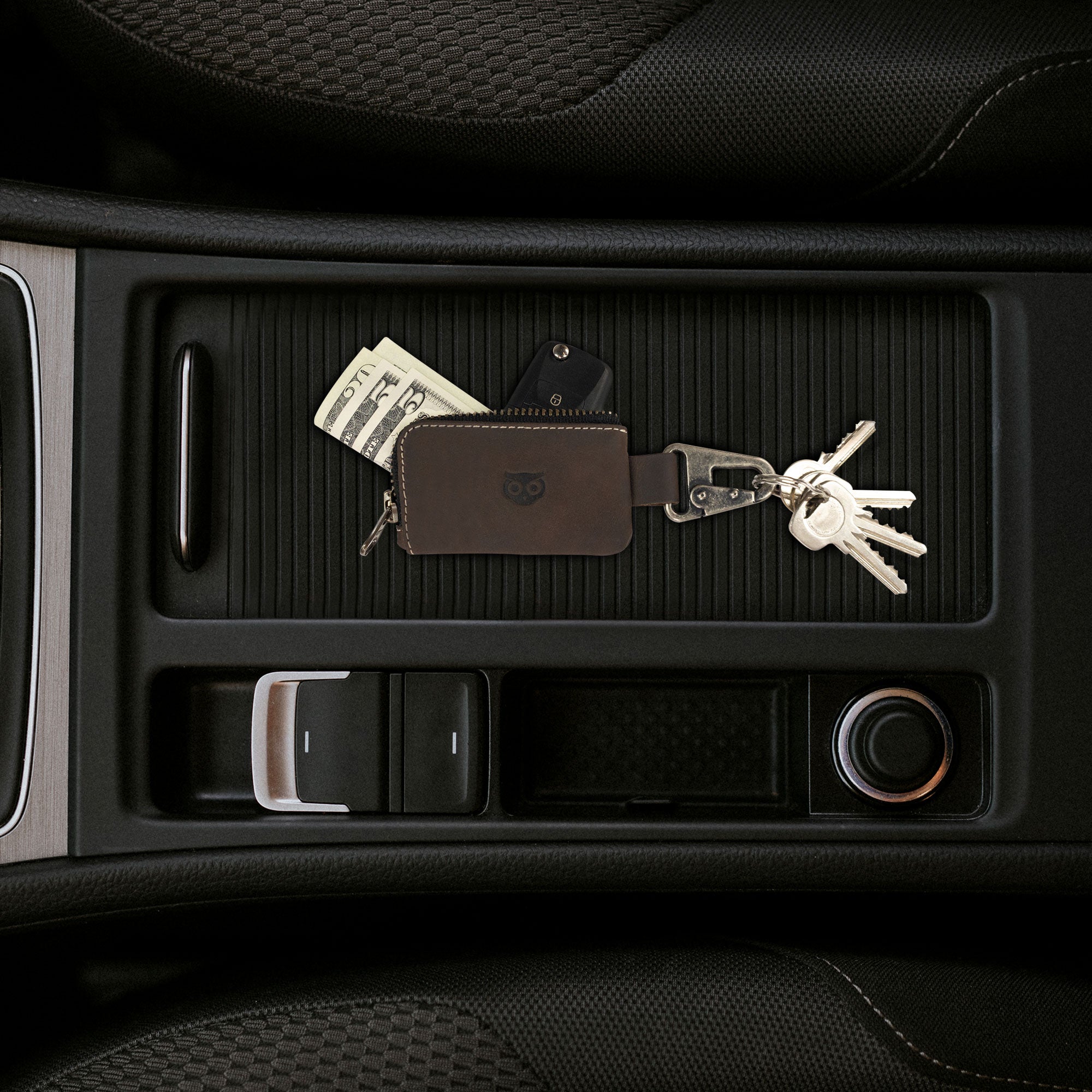 Close-up view of the Car Key Holder in brown by Hide & Drink, displaying its practical features for holding keys and cash while accommodating Headphone and charging Cables, Memory Cards, and Flash Drives. This premium product is made from durable Full Grain Leather with a Nickel Metal Clasp, embodying artisan quality from Small Batch Production in La Antigua Guatemala & Oaxaca Mexico.