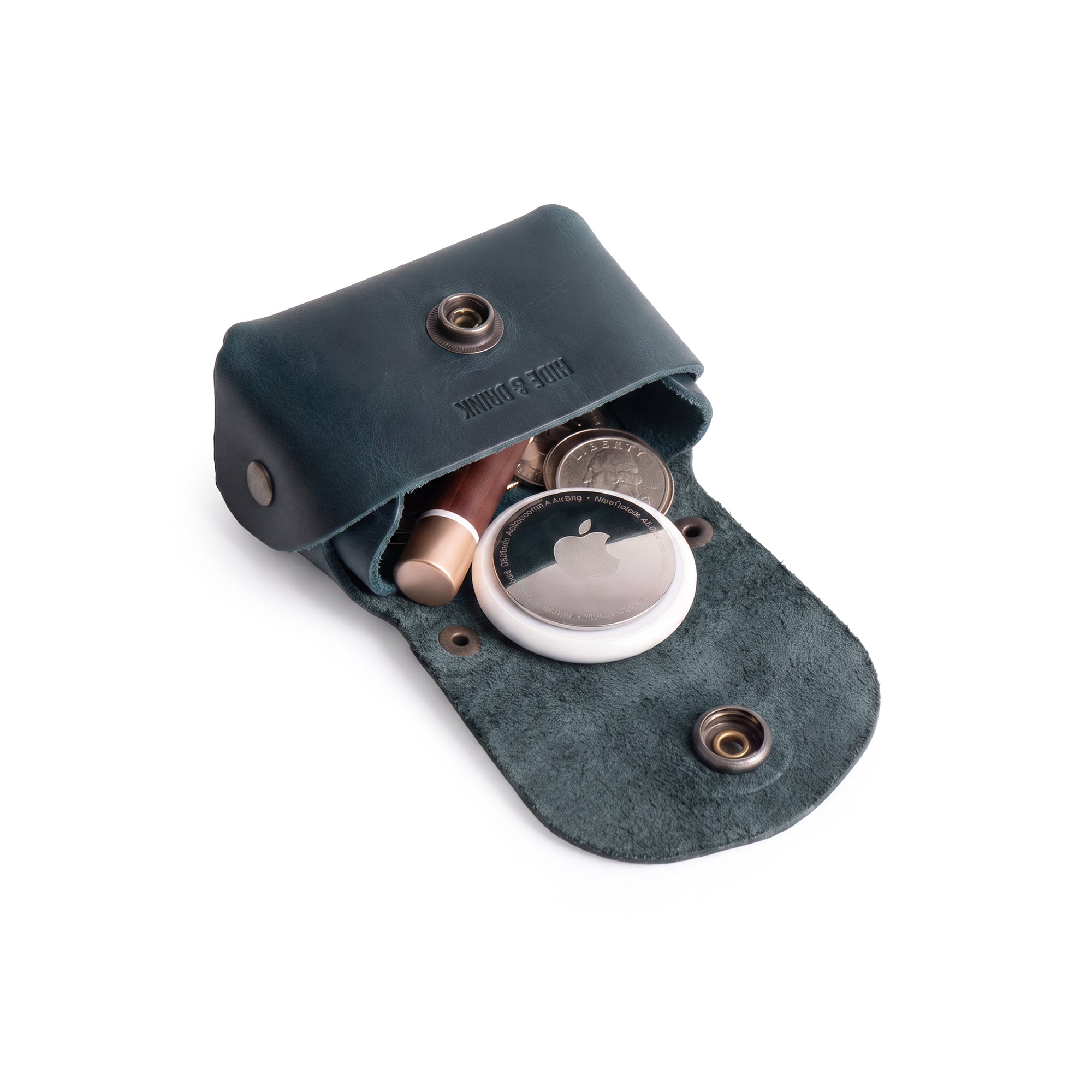 The Tiny Handbag Keychain by Hide & Drink opens to reveal its practical interior, crafted from Full Grain Leather and designed to hold coins and keys. This piece embodies handmade artistry and small batch production, perfect for those who appreciate unique accessories from StockyardX.