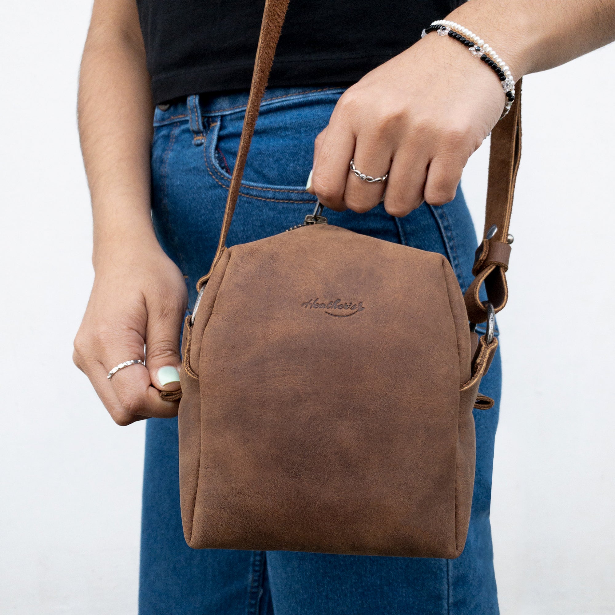 A close-up of Heather's Cube Shaped Bag in use, showcasing its rustic satchel style. This beautiful Full Grain Leather purse is hand cut and sewn, making it a unique addition to any wardrobe, perfect for those who appreciate small batch production.