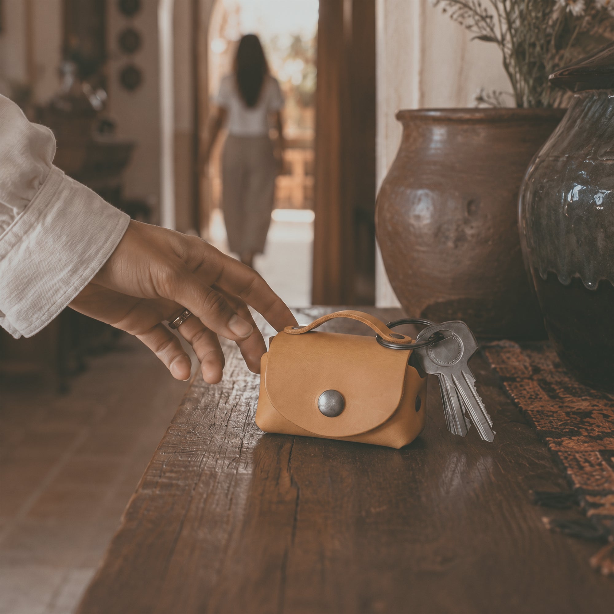Open view of the mustard Tiny Handbag Keychain by Hide & Drink, showcasing a Tiny Handbag with Key Ring Holder with coins inside, crafted from Full Grain Leather. This stylish accessory is part of Small Batch Production, Hand Cut, Hand Sewn, and Fire Branded, proudly made by artisans in La Antigua Guatemala & Oaxaca Mexico.