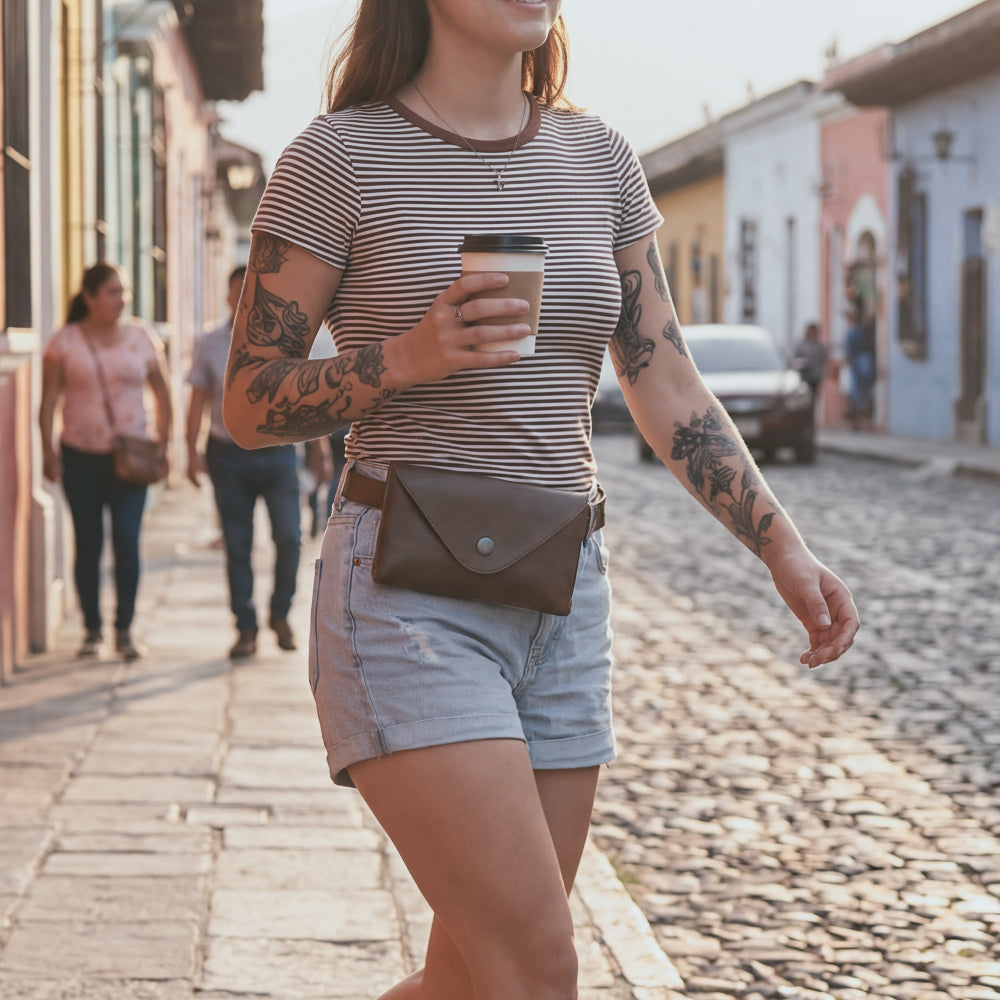 Model wearing Hide & Drink's Fancy Fanny Pack, showcasing how to wear this stylish waist pouch. Made from full grain leather, it's not only practical as a fanny pack but also as a chic vintage purse. Artisan-made with care in small batches in La Antigua Guatemala.