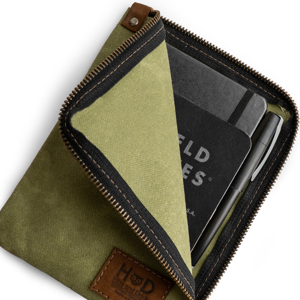 Green Scribbler Case by Hide & Drink, made from Waxed Canvas, designed for notebooks. Features small batch production, hand cut, hand sewn, and fire-branded details. Artisan, handmade in La Antigua Guatemala & Oaxaca Mexico.