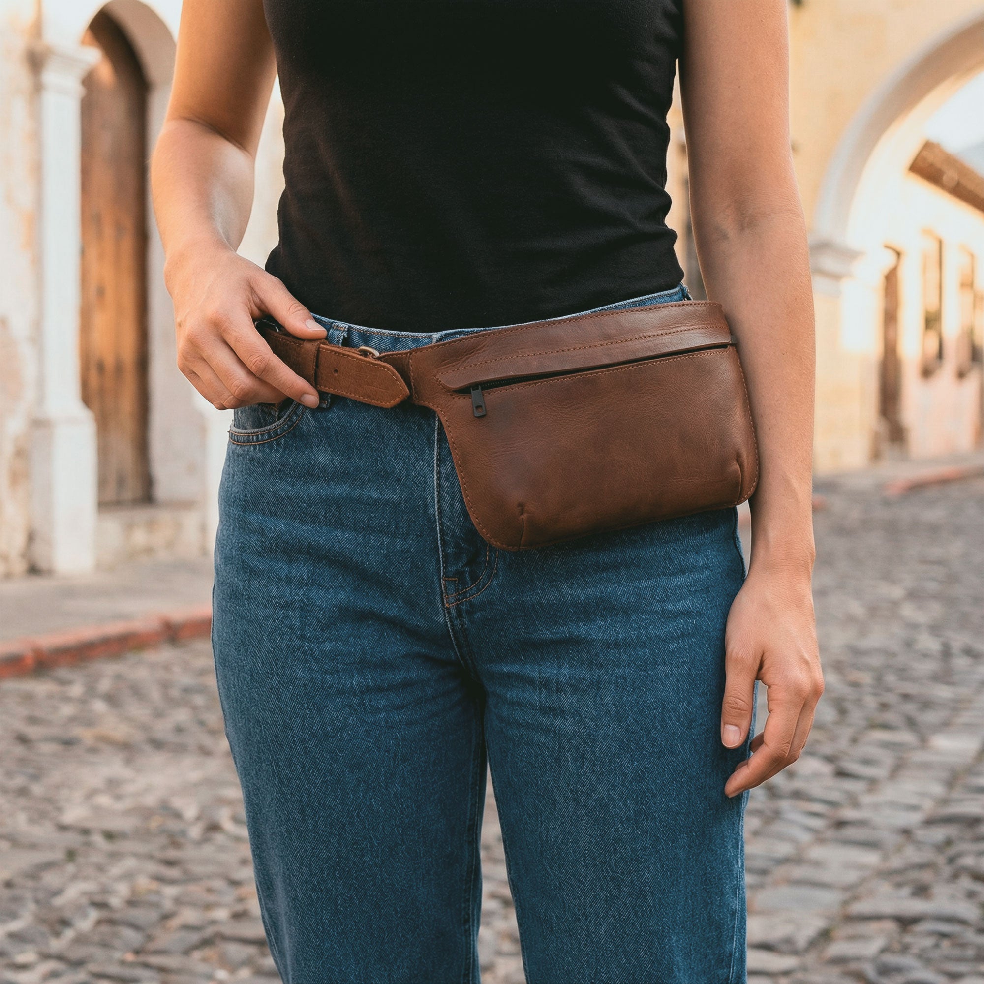 Slim Fanny Pack by Hide & Drink with a rich brown shade showcasing a rectangular design, perfect as a narrow waist bag with an adjustable strap, great for holding phones and small accessories. Made from premium full grain leather, this artisan piece is hand cut and sewn in La Antigua Guatemala.