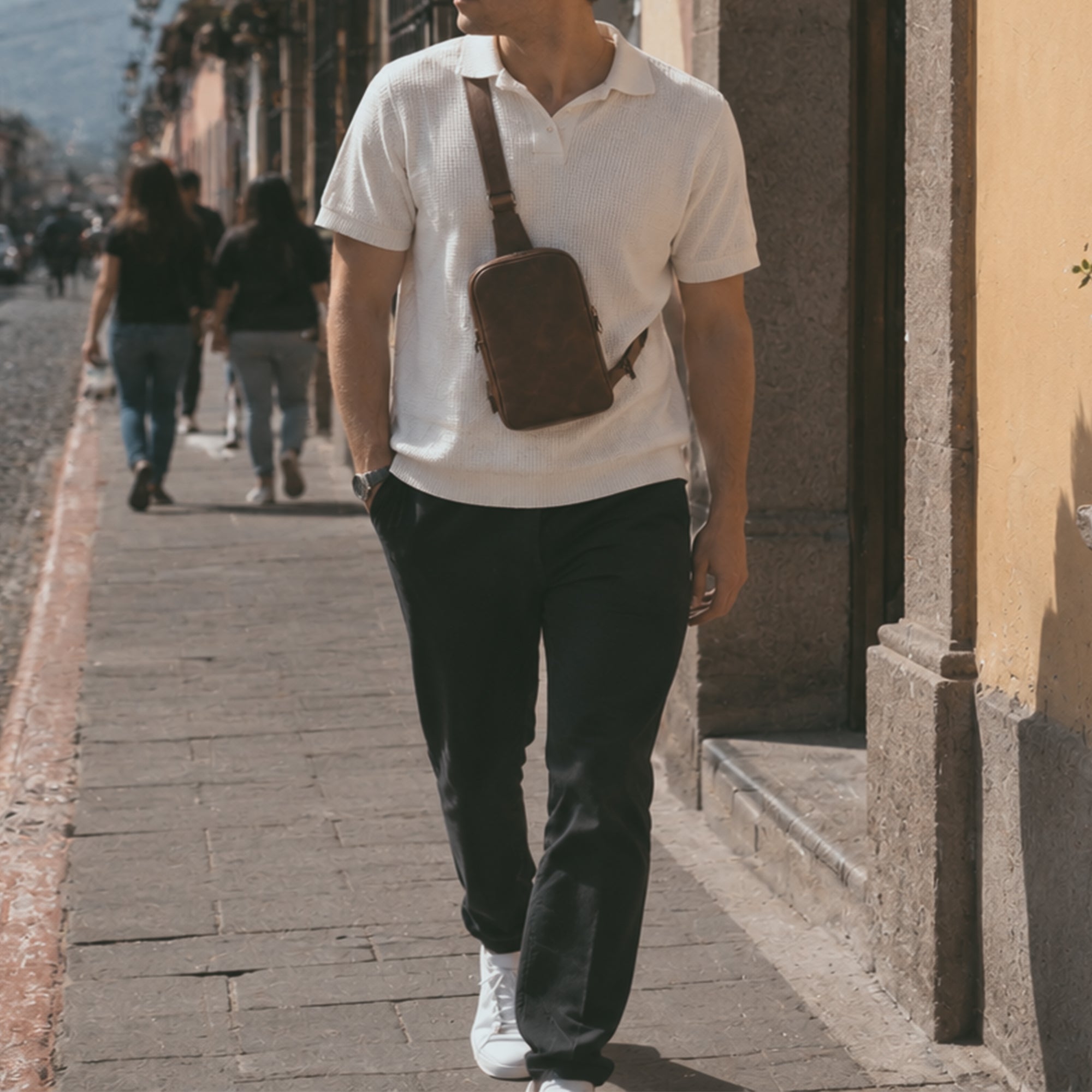A model wearing the Hide & Drink Crossbody Rounded Bag, demonstrating how to wear this Rounded Crossbody Bag with Adjustable Strap as a stylish messenger bag. Crafted from durable Full Grain Leather, this travel accessory reflects the quality of artisan, handmade creations from La Antigua Guatemala & Oaxaca Mexico.