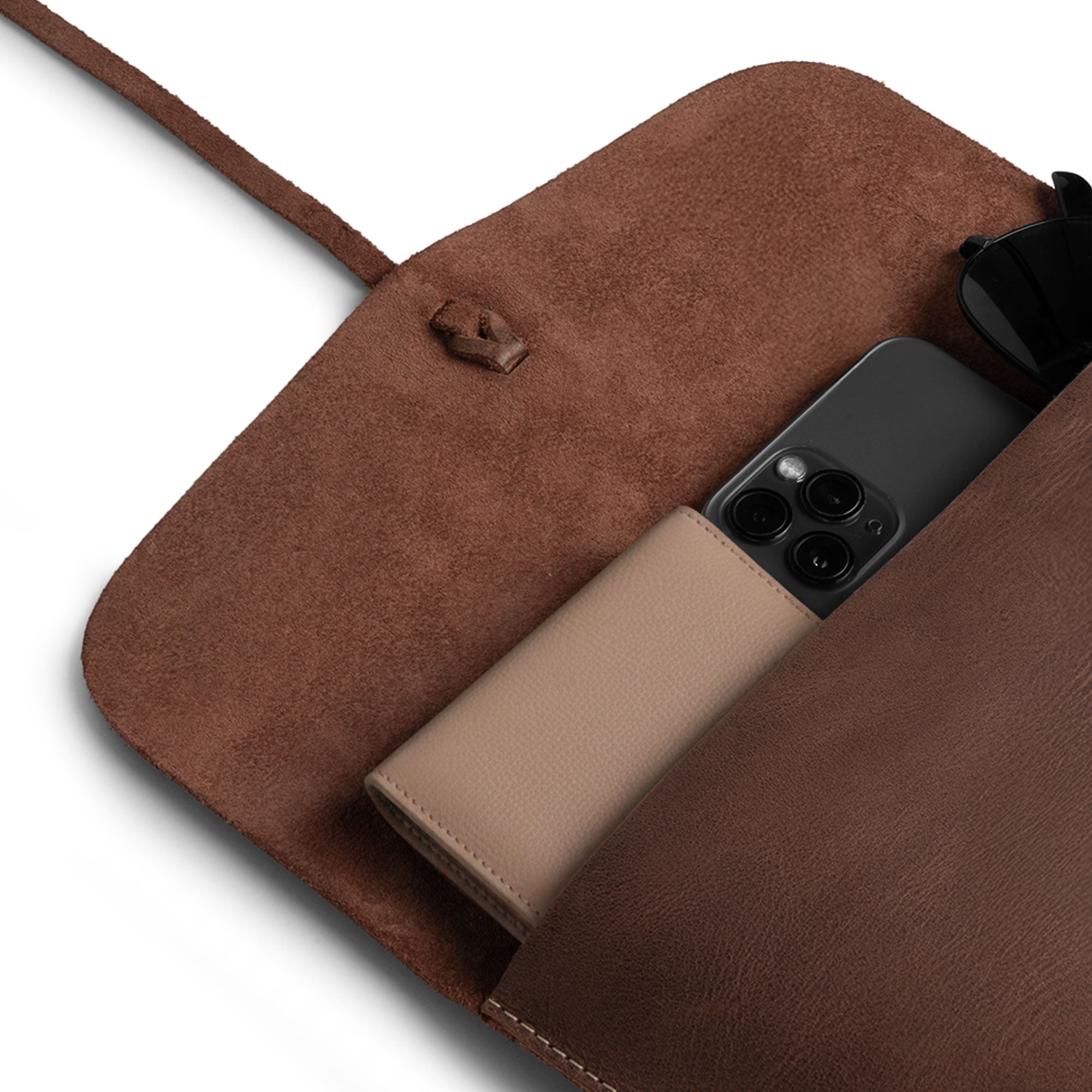 View of Heather's Minimalist Clutch Bag with personal items, demonstrating its functionality for cards, money, and coins. This full grain leather bag is also ideal for makeup and other essentials, handcrafted in La Antigua Guatemala & Oaxaca Mexico through small batch production.