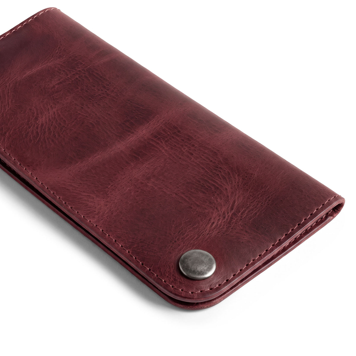 Showcasing the Red Double Snap Folio Wallet by Hide & Drink, a vibrant and stylish full grain leather holder designed for cash and cards. This rectangular flat bill holder with card slot acts as an ideal night bag and travel accessory, showcasing the artisan craftsmanship from La Antigua Guatemala & Oaxaca Mexico.
