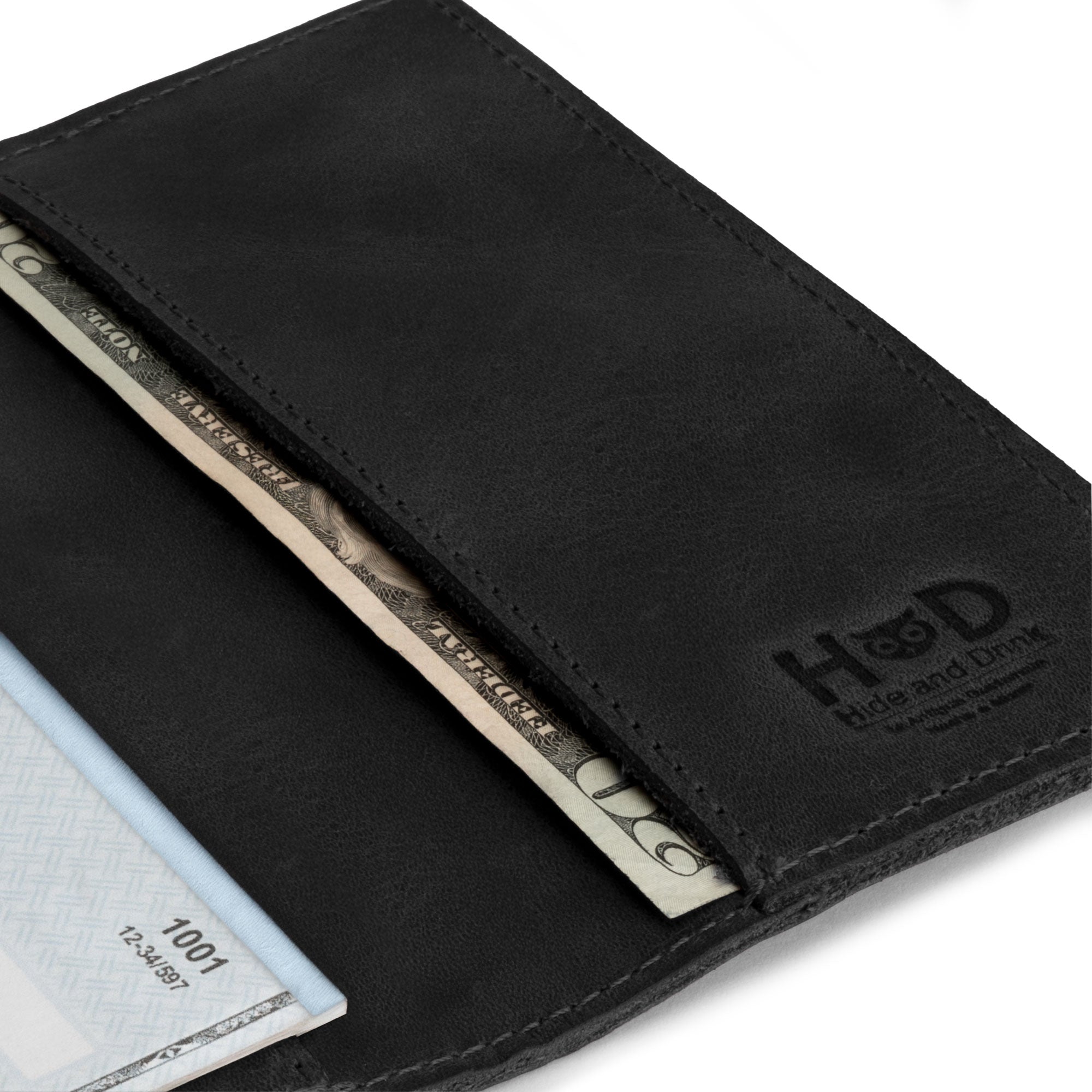 Close-up of the black Checkbook Leather Cover by Hide & Drink, perfect as a minimalist organizer for standard checkbooks. This handmade item is crafted from full grain leather and showcases artisan craftsmanship, made in La Antigua Guatemala and Oaxaca Mexico through small batch production.