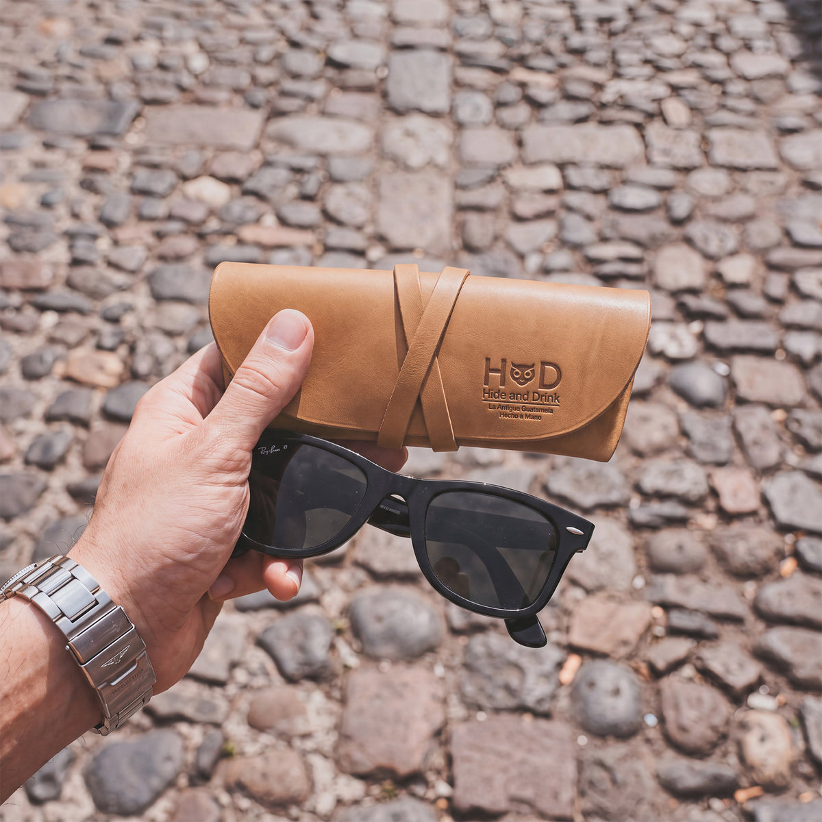 Hide & Drink Leather Sunglass Wrap showcases beautiful full grain leather in a stylish design. This eye glasses storage is perfect for travel lovers, providing a snug fit for your sunglasses. Hand cut and sewn by artisans in La Antigua Guatemala, it ensures lasting durability.