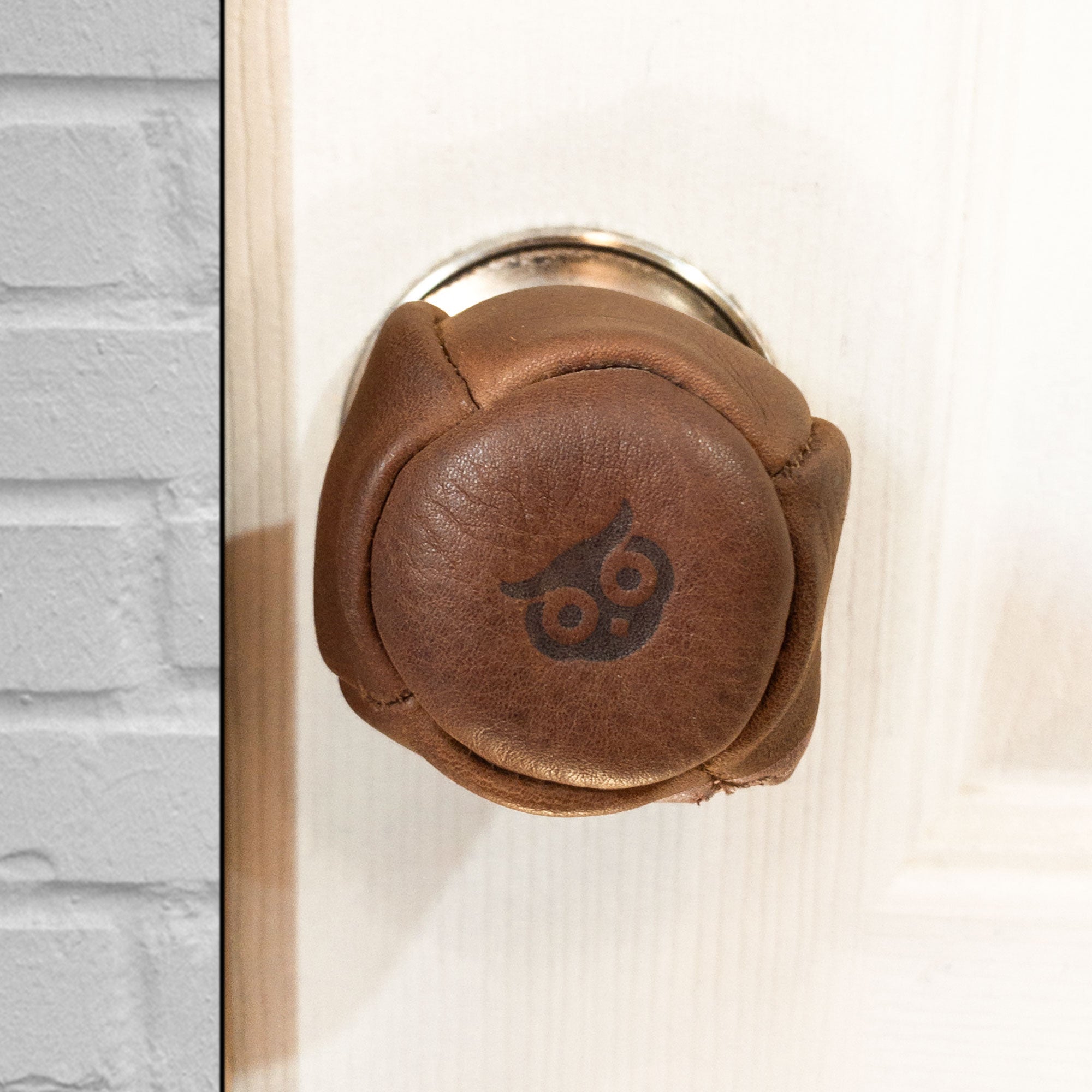 Hide & Drink's stylish Door Knob Cover showcasing a rustic Full Grain Leather design, perfect for safety as a baby proof door knob cover. This artisan, handmade piece from La Antigua Guatemala boasts small batch production, fire branded details, and expert craftsmanship.